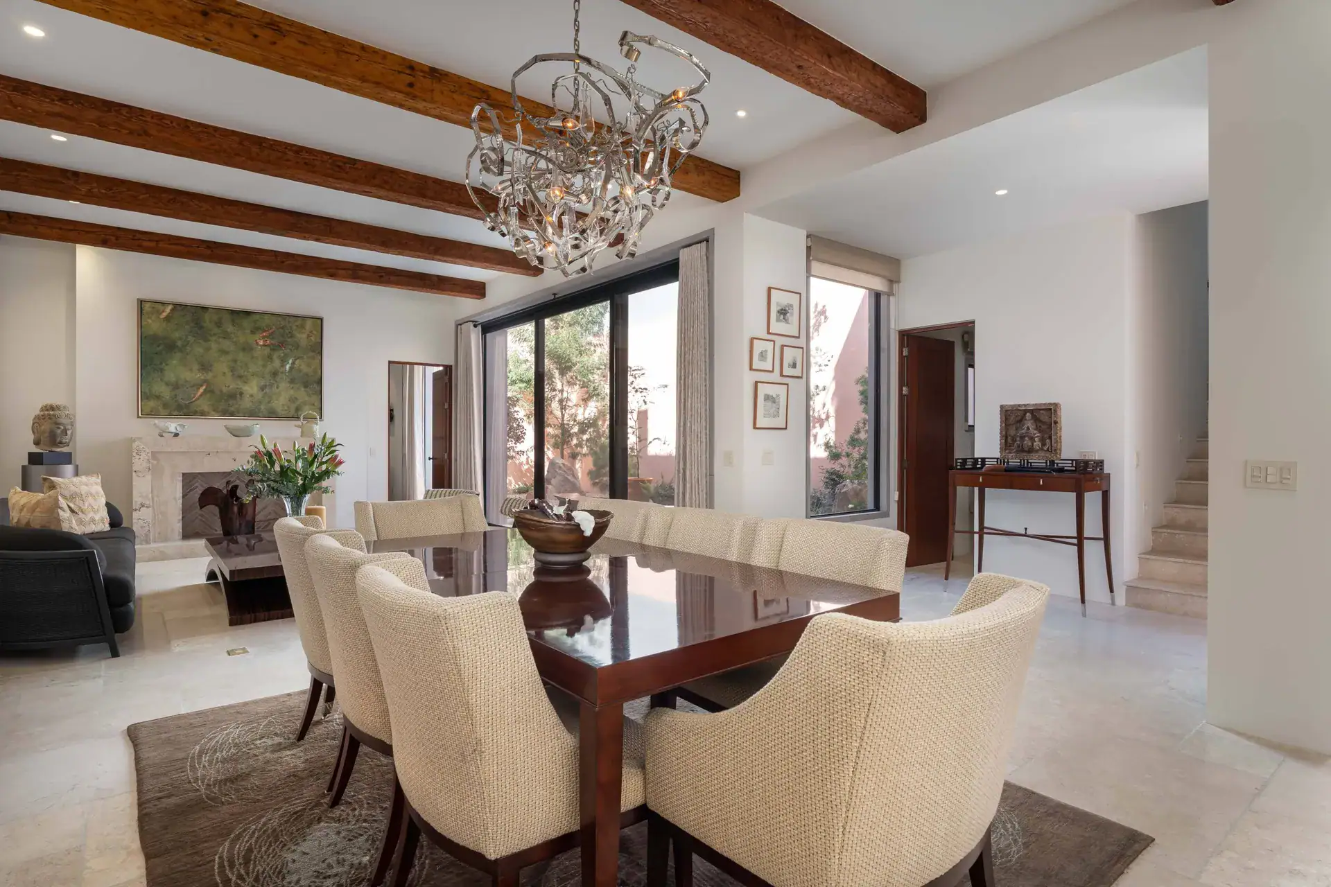Casa Nobel, dining table, living room and a glass wall to the courtyard under wood beams, San Miguel de Allende