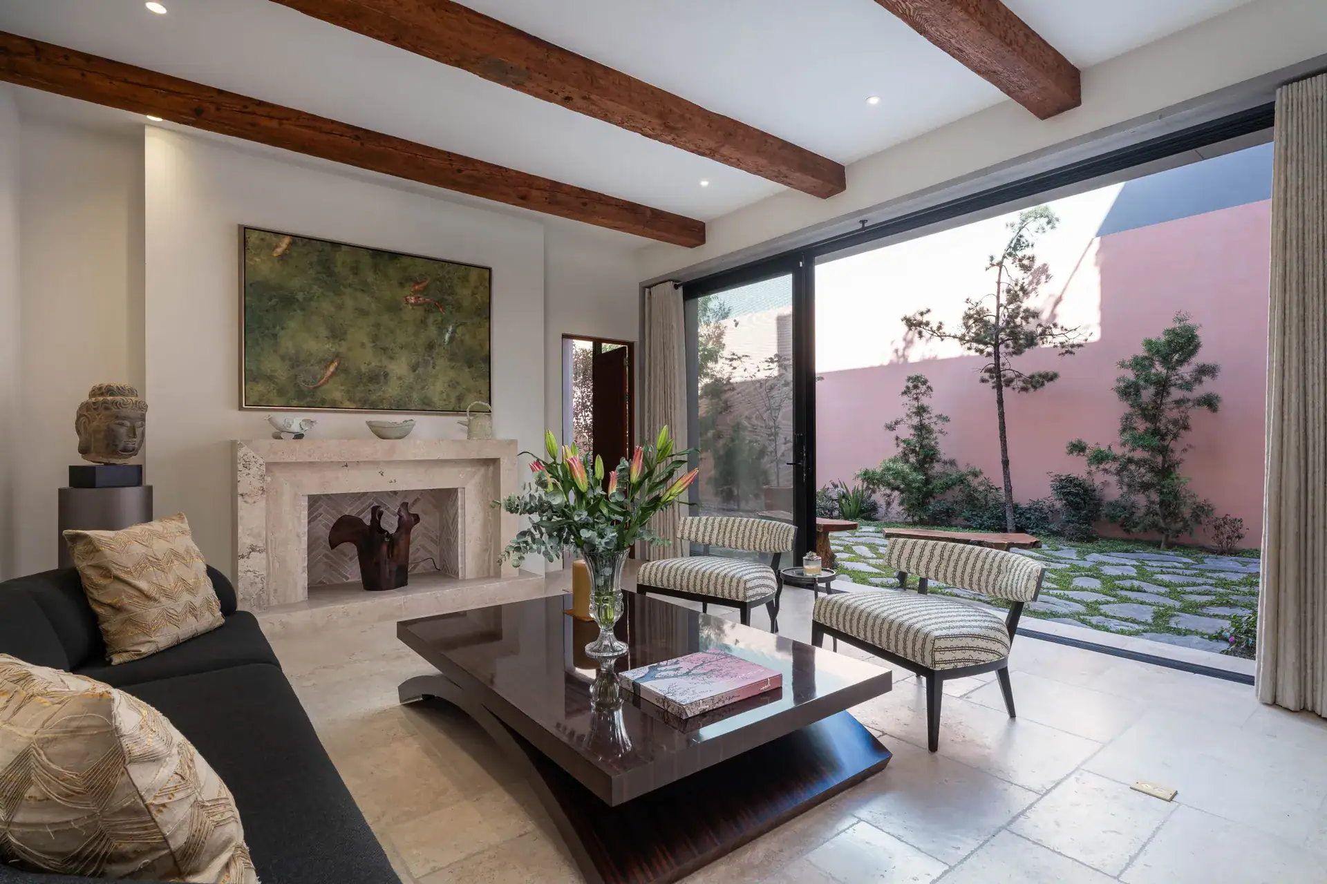 Casa Nobel, living room with a sliding glass wall to the courtyard and striped armchairs, San Miguel de Allende