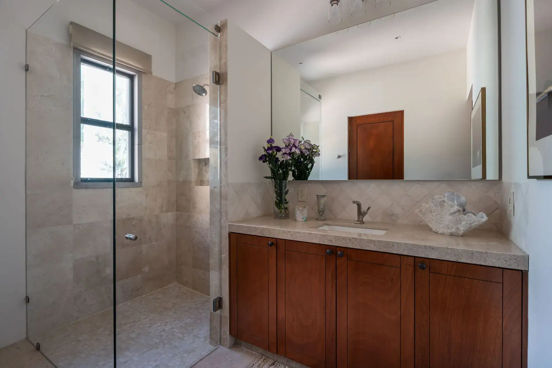 Casa Nobel, bathroom with a glass shower, a wood vanity and a stone counter, San Miguel de Allende