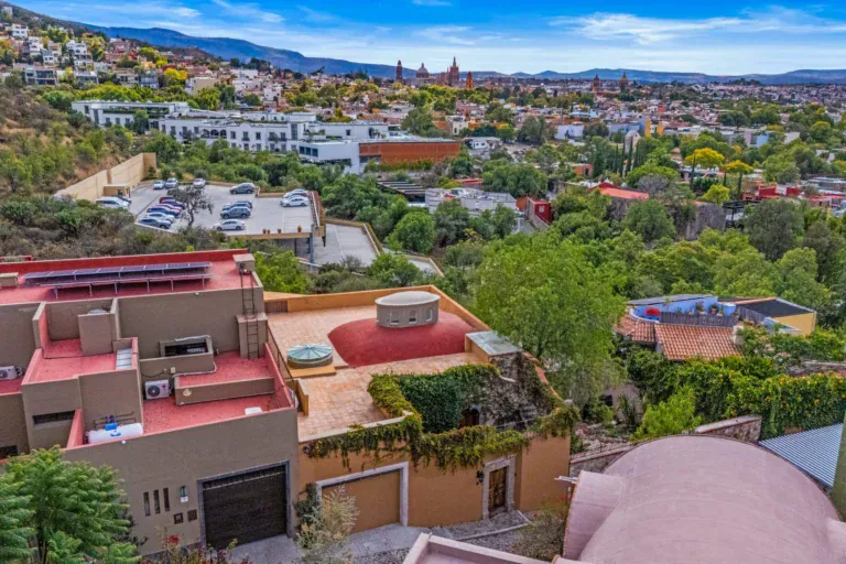 Casa Noche Magica, aerial view of the rooftops with a pink dome and the town and hills in the distance, San Miguel de Allende