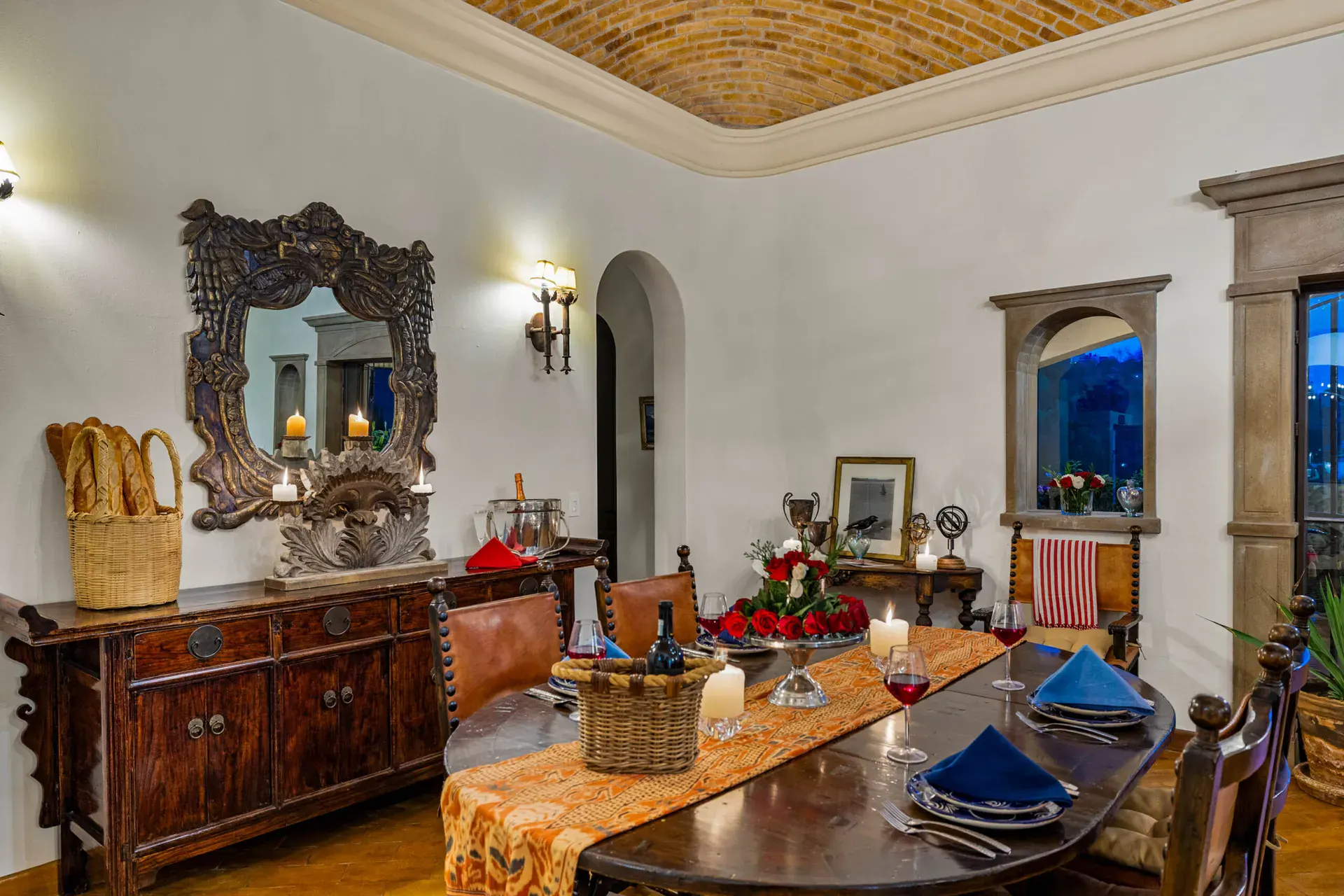Casa Noche Magica, dining table with a carved sideboard and a mirror in an arched niche, San Miguel de Allende