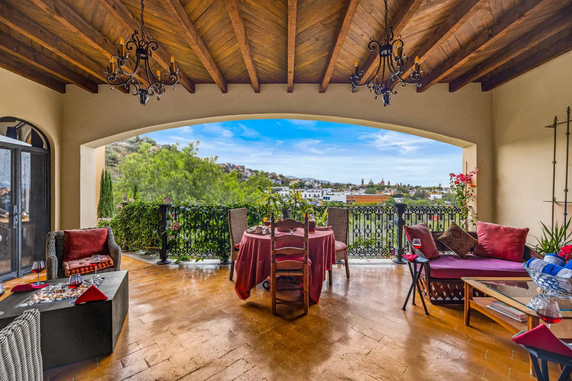 Casa Noche Magica, upper-level sitting room opening to a terrace with a view of the hills and a round dining table, San Miguel de Allende