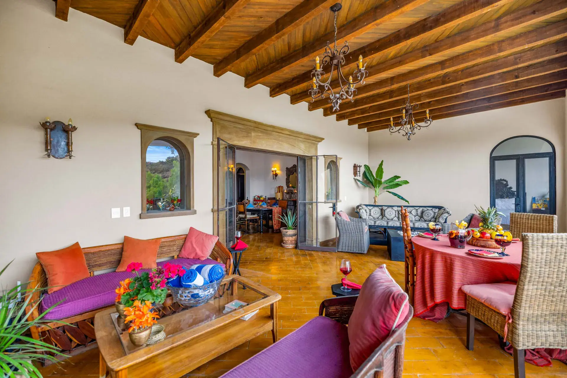 Casa Noche Magica, upper-level lounge with wood-beam ceiling, banquette seating and a dining table set for lunch, San Miguel de Allende