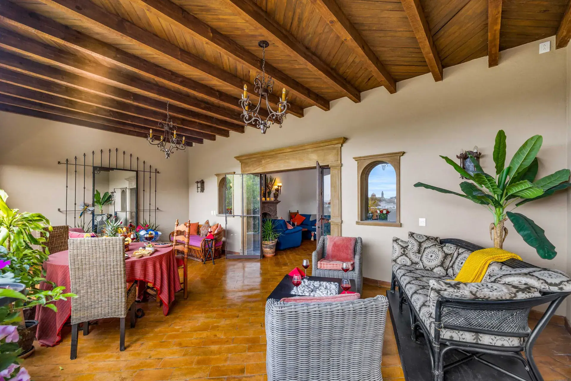 Casa Noche Magica, upper-level lounge and dining area with a stone-framed opening and a banana plant, San Miguel de Allende