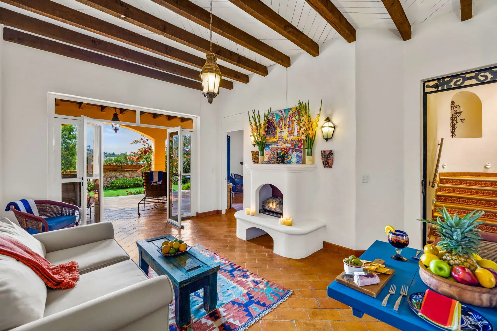 Casa Noche Magica, guest suite with a corner fireplace, a blue coffee table, a rug and a staircase leading to a terrace, San Miguel de Allende