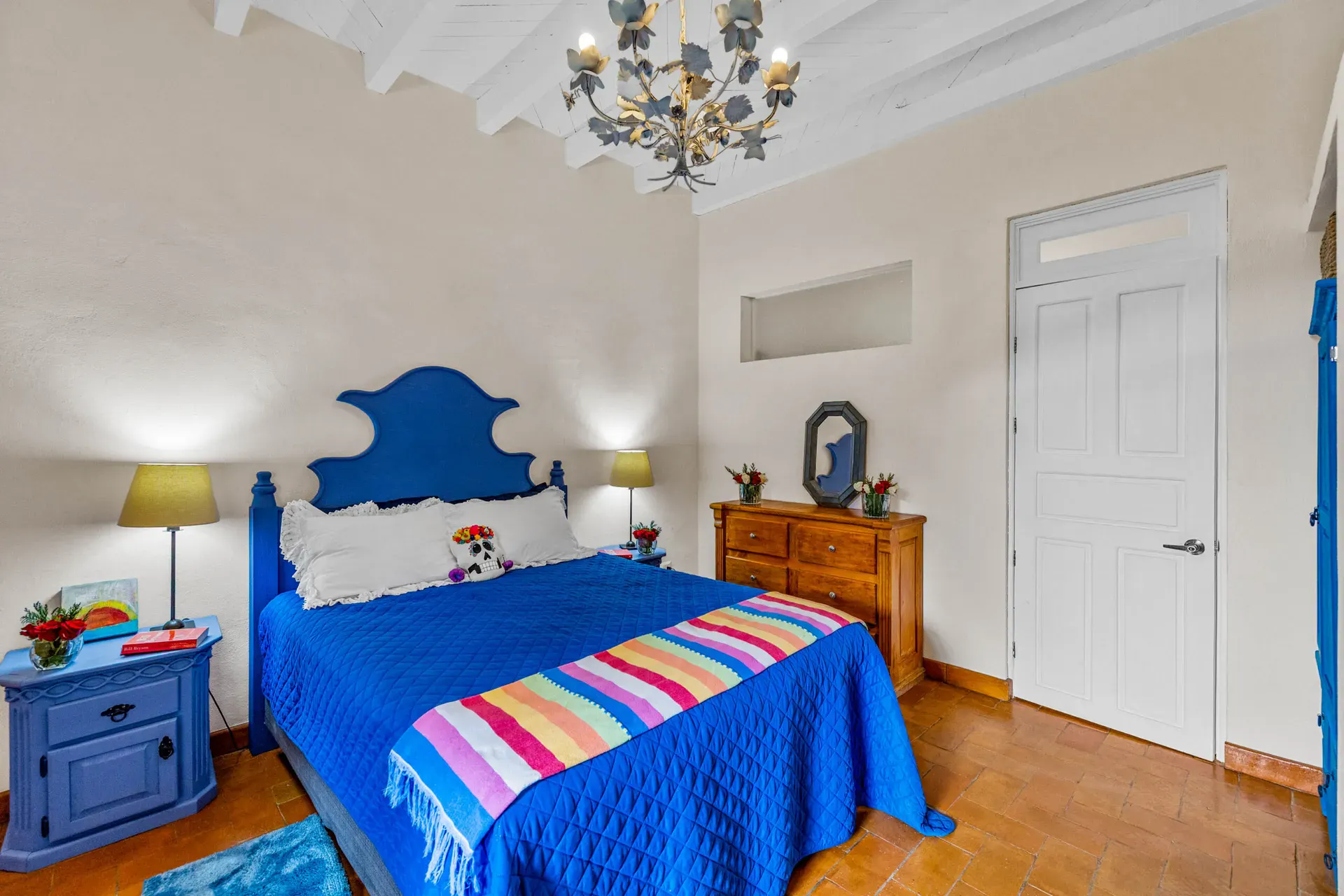 Casa Noche Magica, guest bedroom with a blue bed and a blue nightstand under a leaf chandelier, San Miguel de Allende