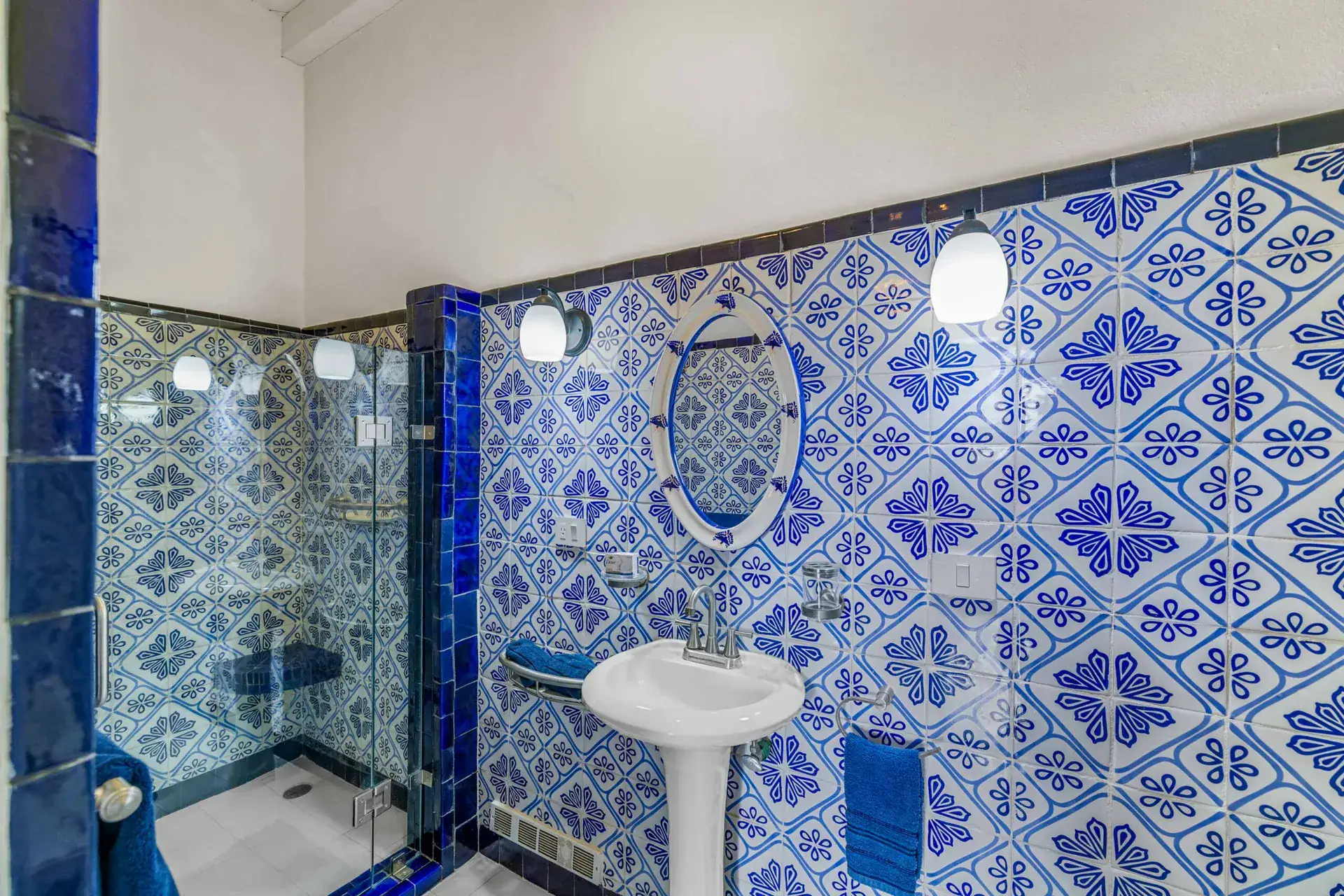 Casa Noche Magica, guest bathroom with blue and white Talavera tile, a pedestal sink and a glass shower, San Miguel de Allende