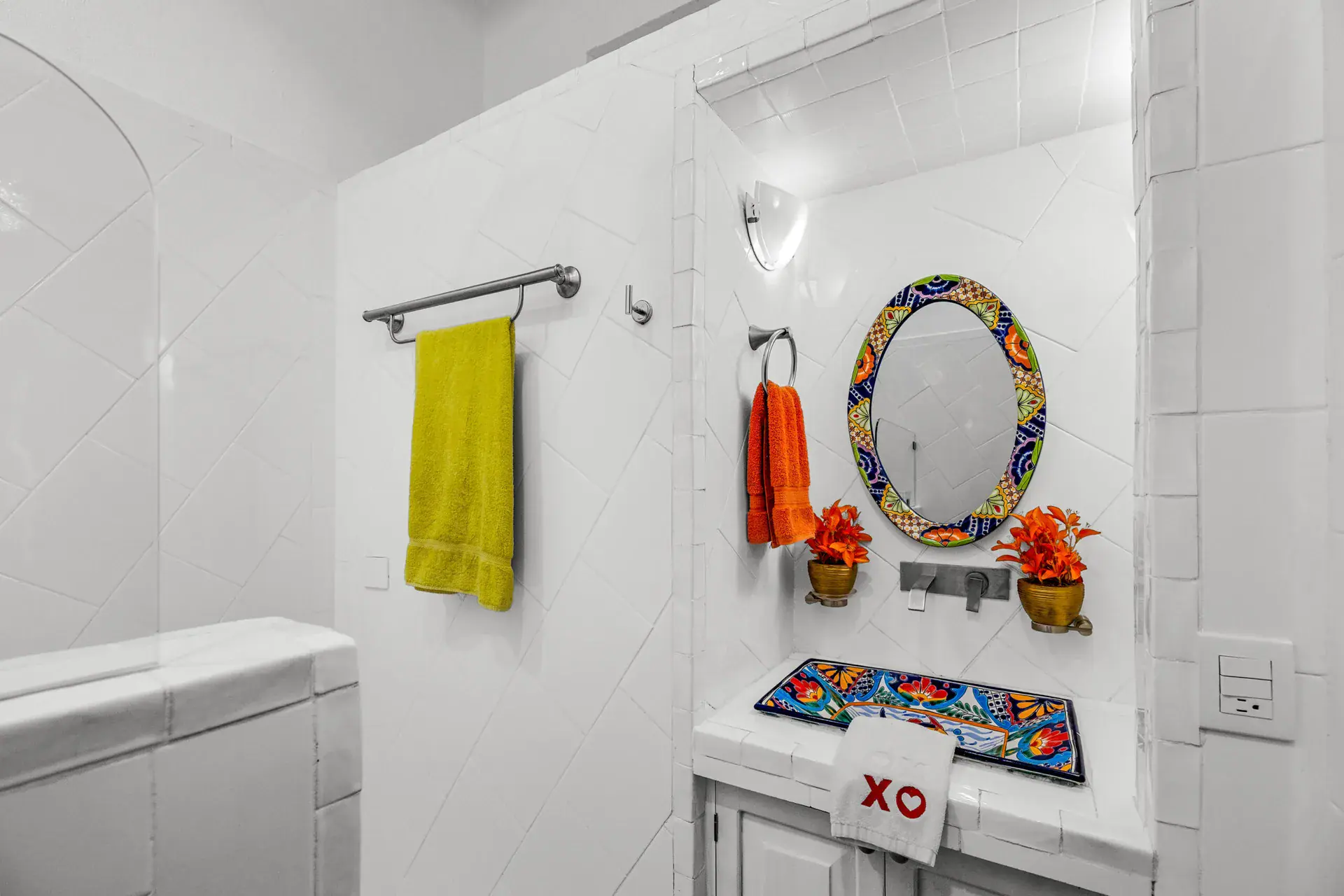 Casa Noche Magica, guest bathroom with white tile, a Talavera sink and an oval mirror, San Miguel de Allende