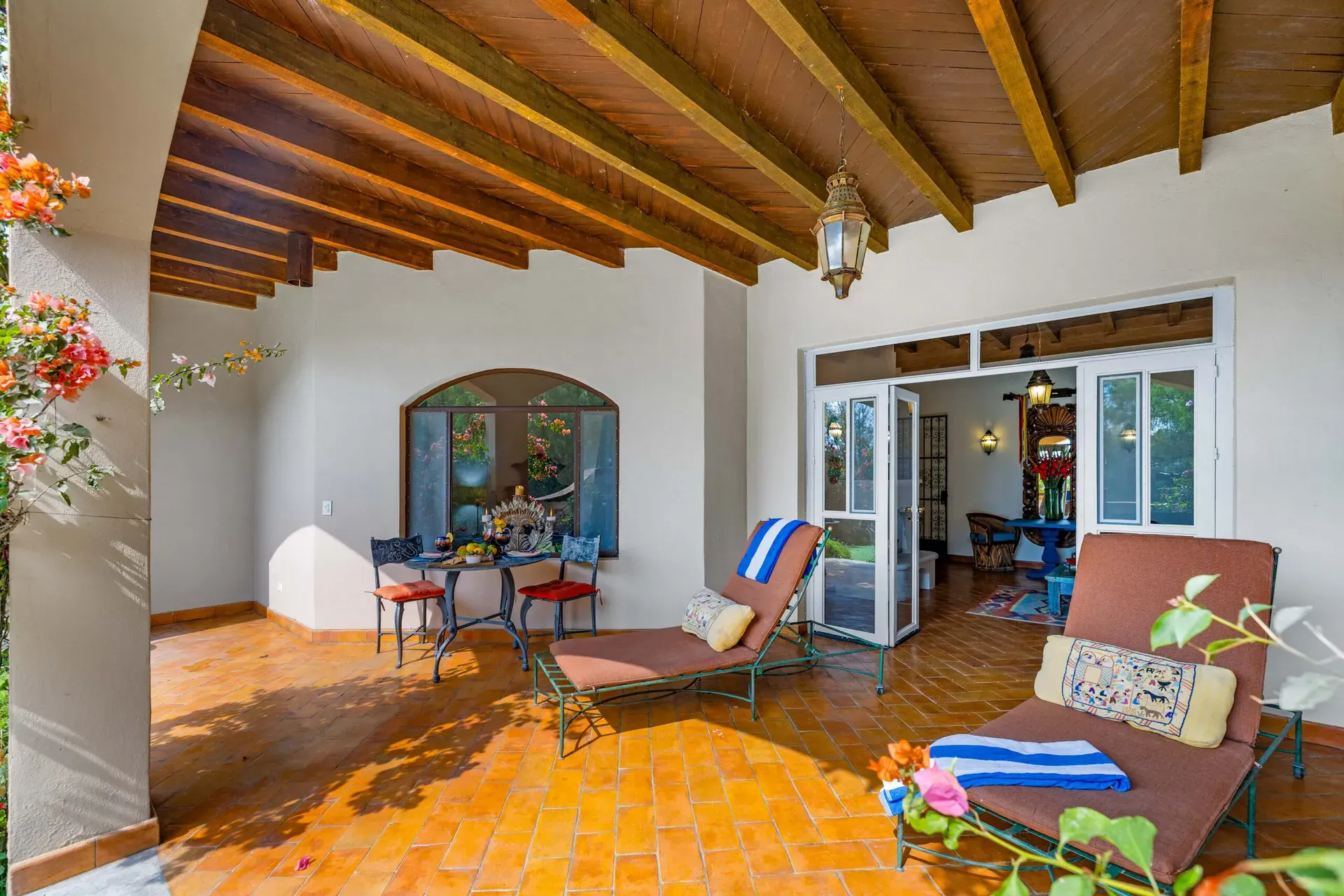 Casa Noche Magica, covered terrace with lounge chairs, a round table and French doors to the guest suite, San Miguel de Allende