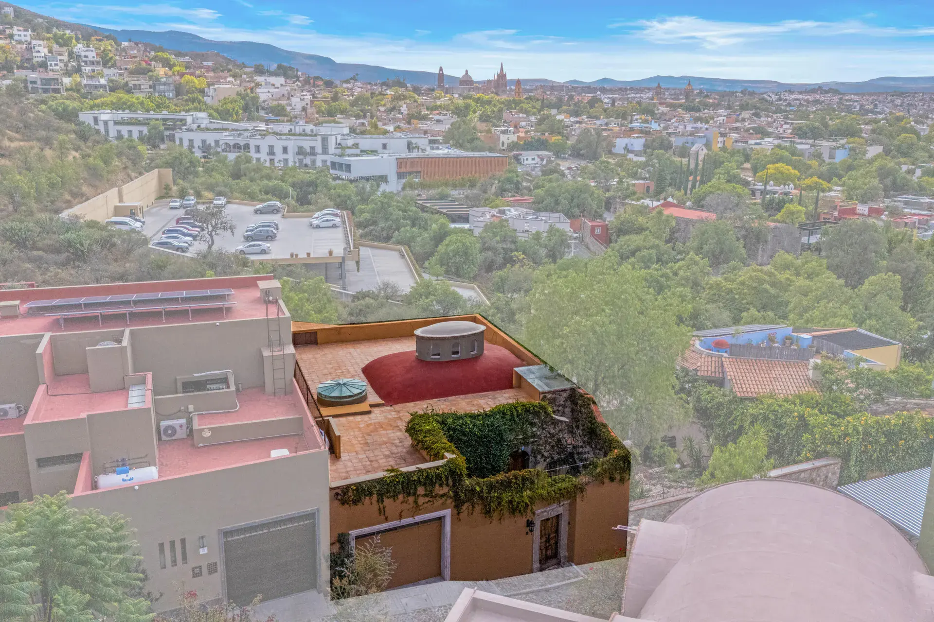 Casa Noche Magica, aerial view of the rooftops with a pink dome and the town in the distance, San Miguel de Allende