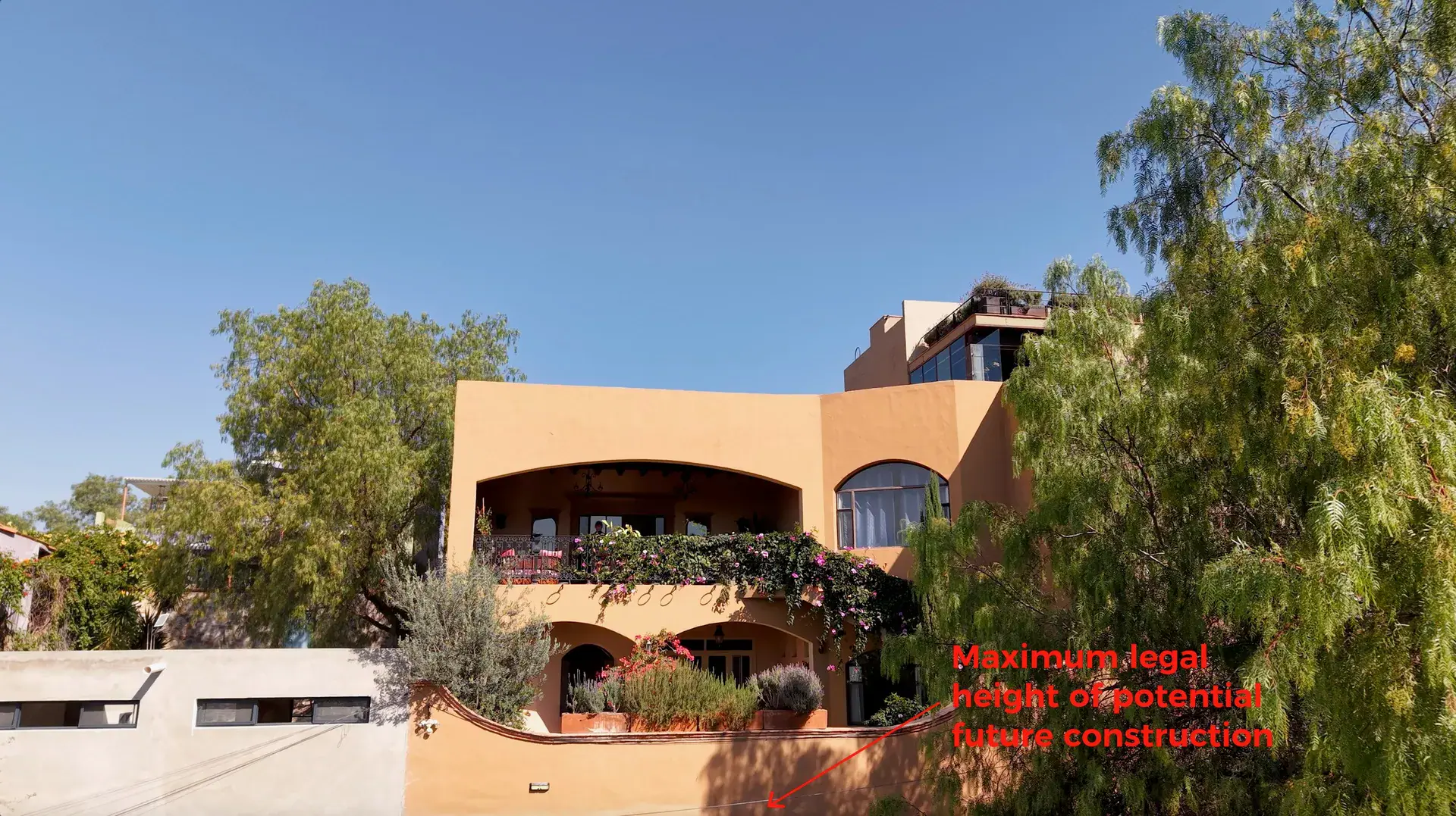Casa Noche Magica, photo of the house with a red annotation of the maximum legal height of future neighboring construction, San Miguel de Allende