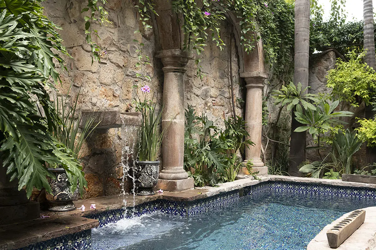 Casa Nola, courtyard pool with a tiled fountain wall and a stone arcade, San Miguel de Allende