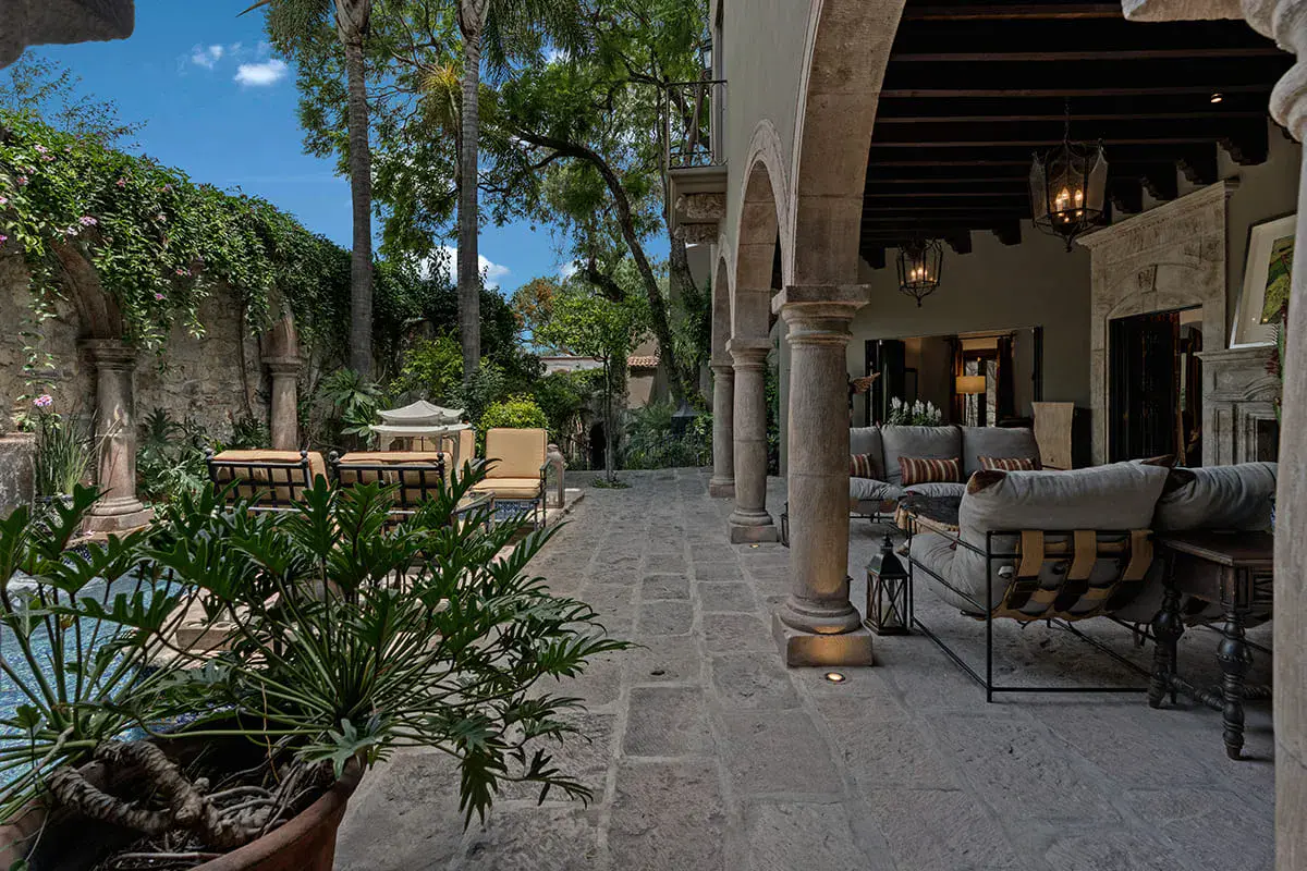 Casa Nola, covered stone terrace with lounge seating beside a garden, San Miguel de Allende