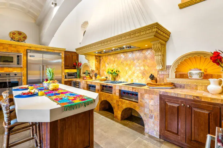 Casa Nostra Familia, kitchen with a carved wood hood, a talavera tile backsplash and a large island, San Miguel de Allende