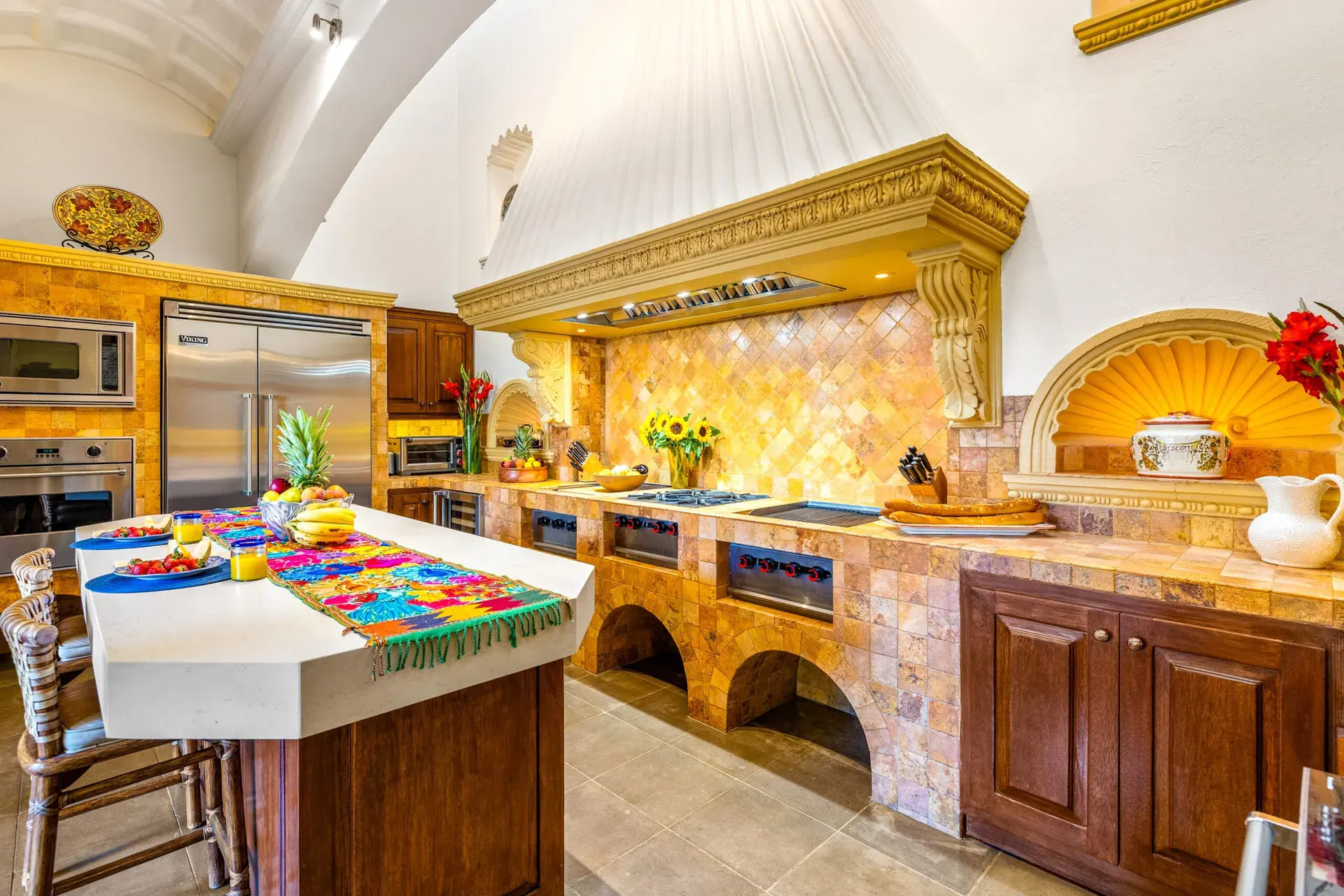 Casa Nostra Familia, kitchen with a carved wood hood, a talavera tile backsplash and a large island, San Miguel de Allende