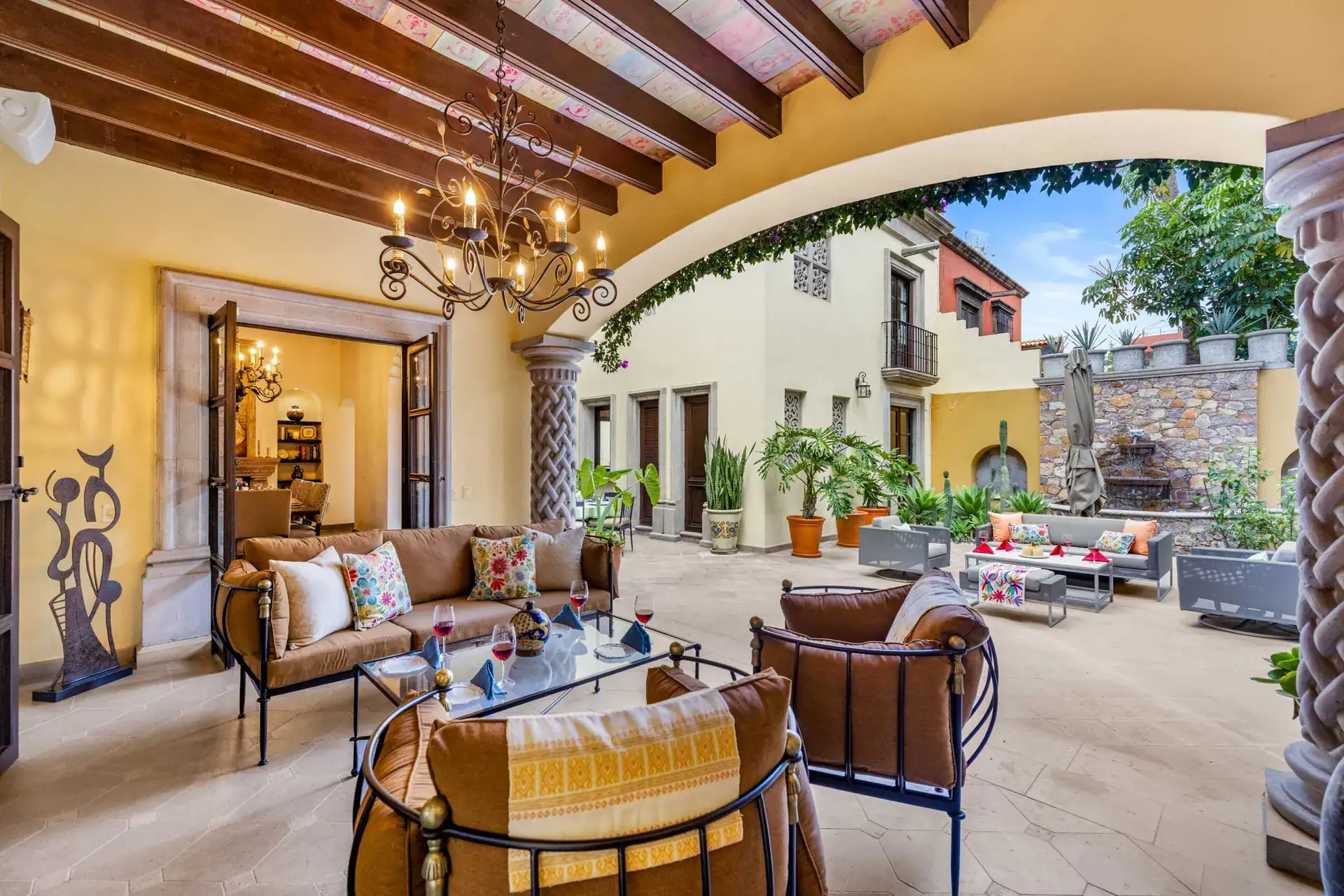 Casa Nostra Familia, courtyard lounge with leather armchairs and an iron chandelier, San Miguel de Allende