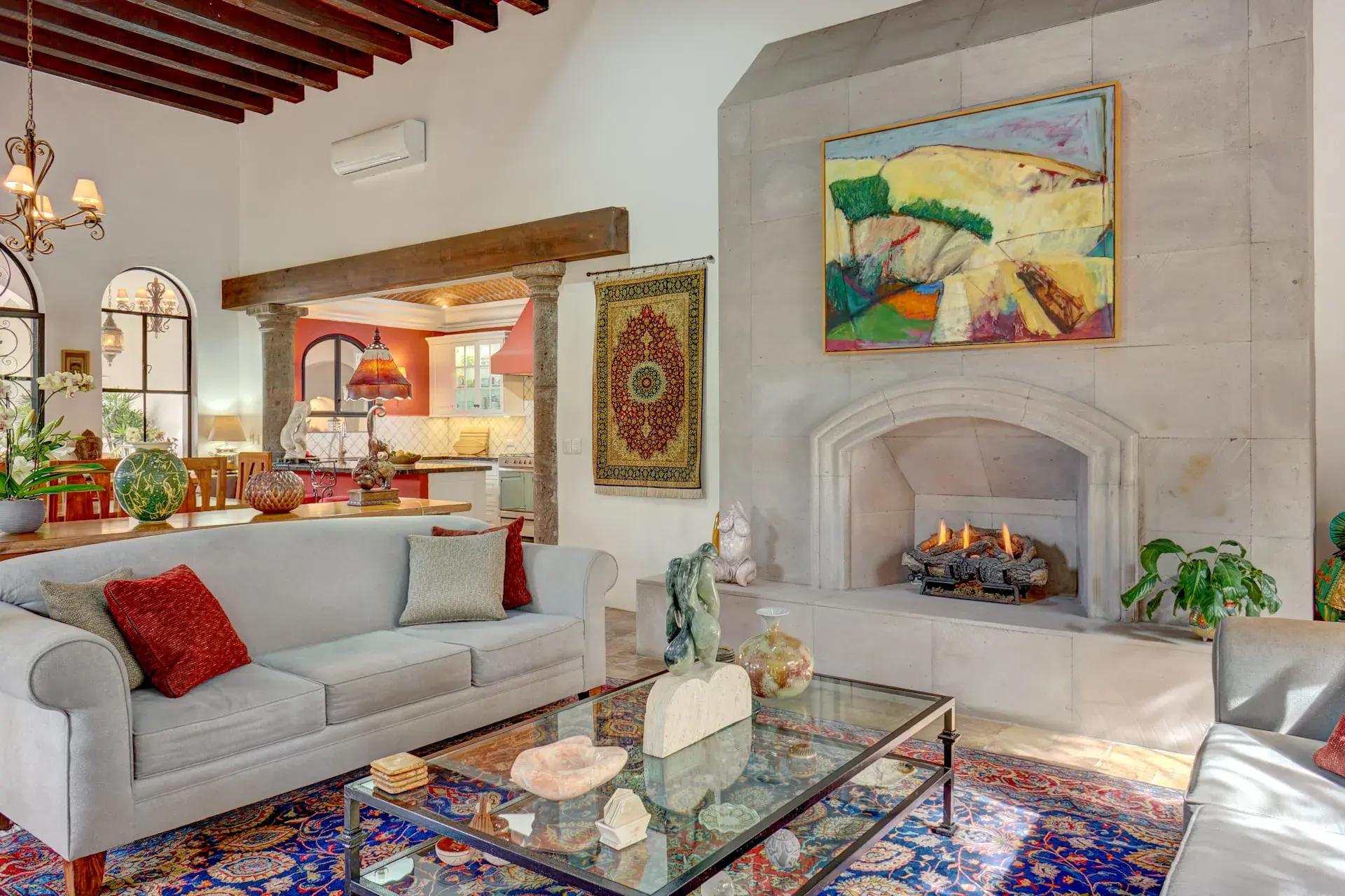 Casa Oasis, living room with a fireplace, gray sofa and a colorful rug, San Miguel de Allende