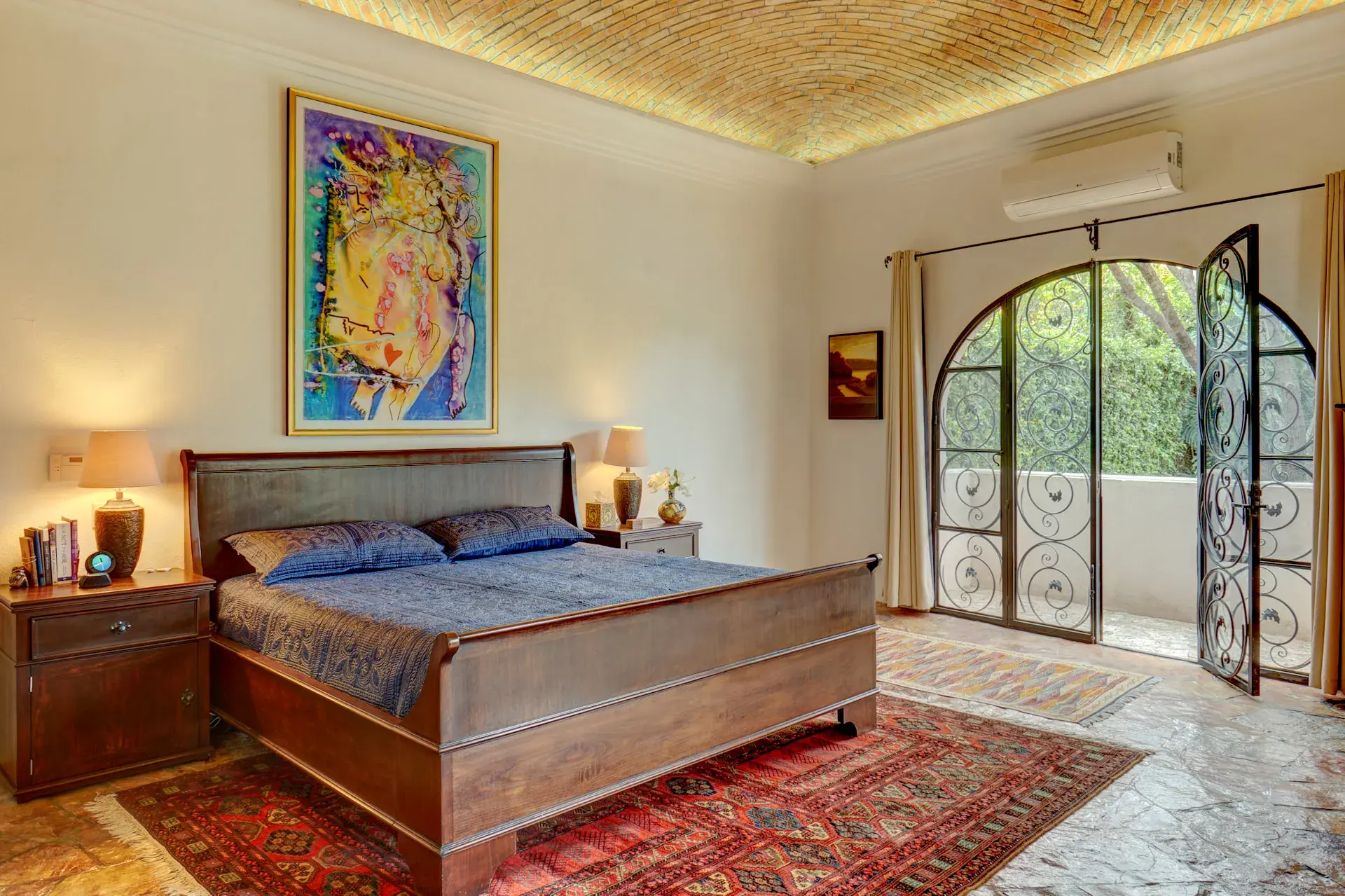 Casa Oasis, primary bedroom with a wood bed, a vaulted brick ceiling and arched iron doors, San Miguel de Allende