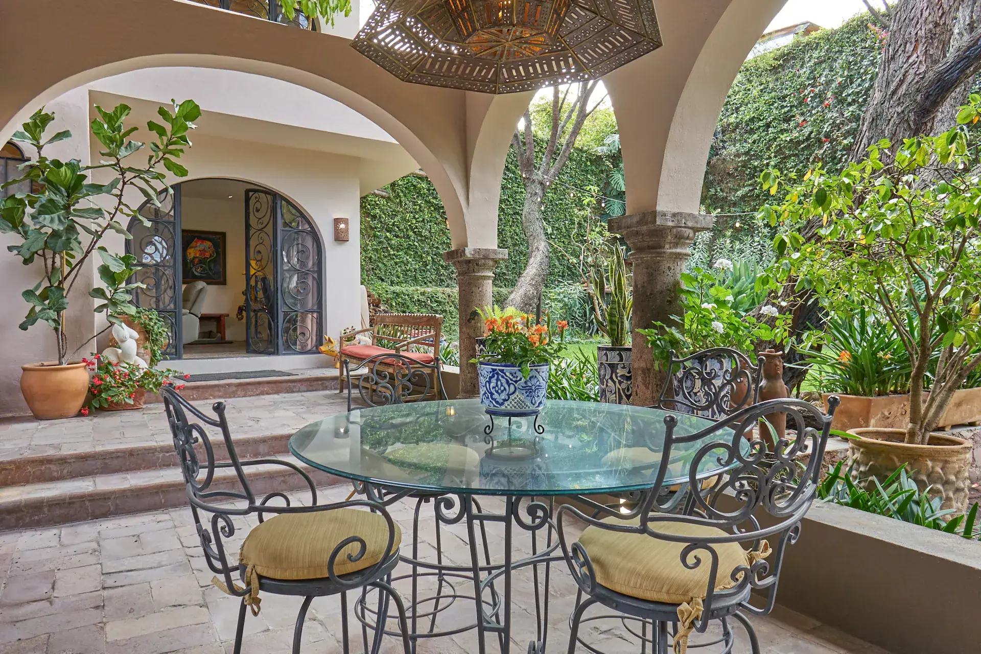 Casa Oasis, patio with a glass dining table under an arched roof, San Miguel de Allende