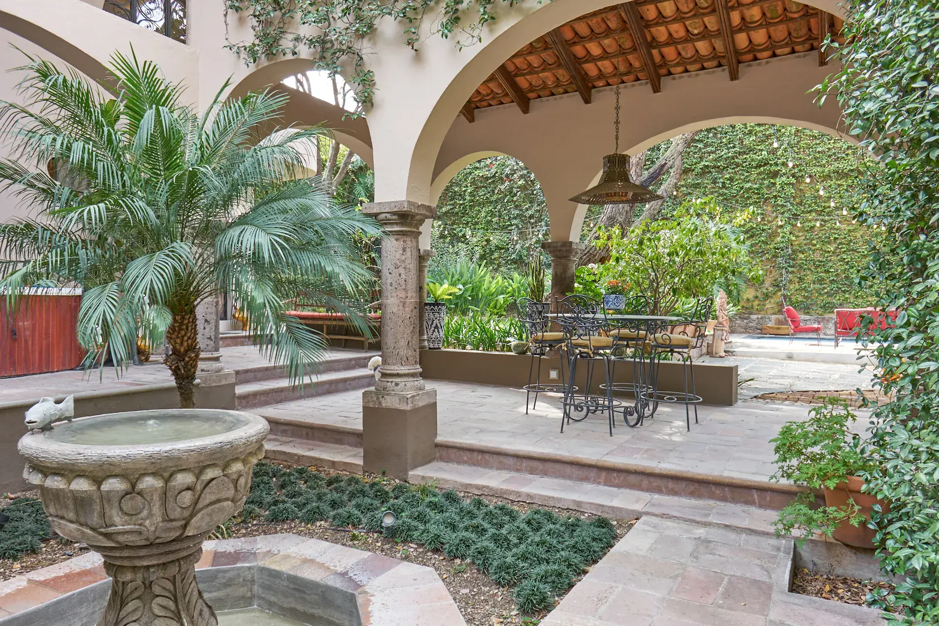 Casa Oasis, courtyard with a stone fountain and a palm beside the loggia, San Miguel de Allende