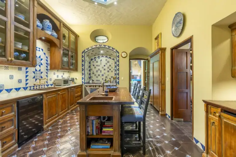 Casa Obelisco, kitchen with wood cabinets, blue and white tile and a center island, San Miguel de Allende