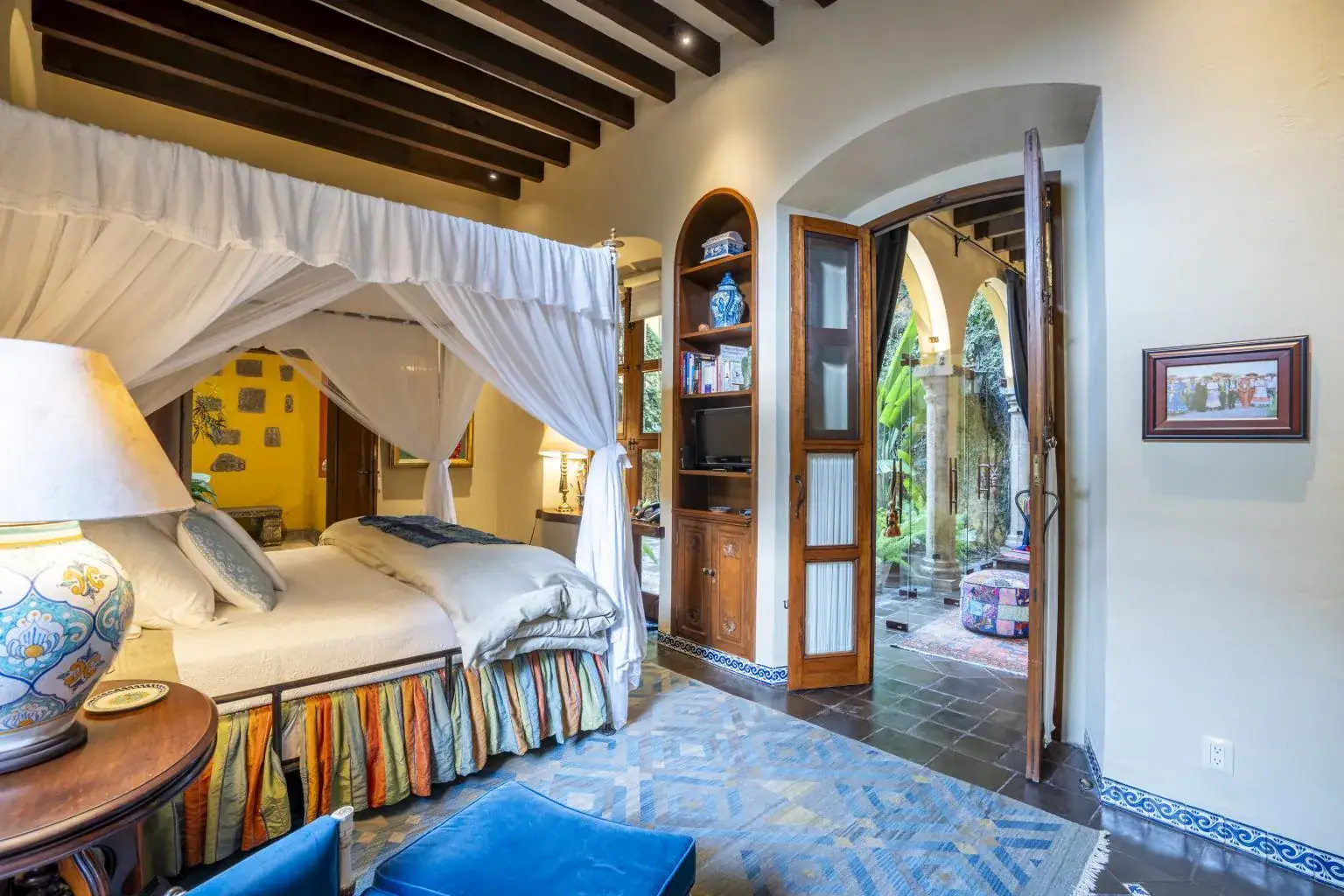 Casa Obelisco, primary bedroom with a canopy bed and white drapes, San Miguel de Allende