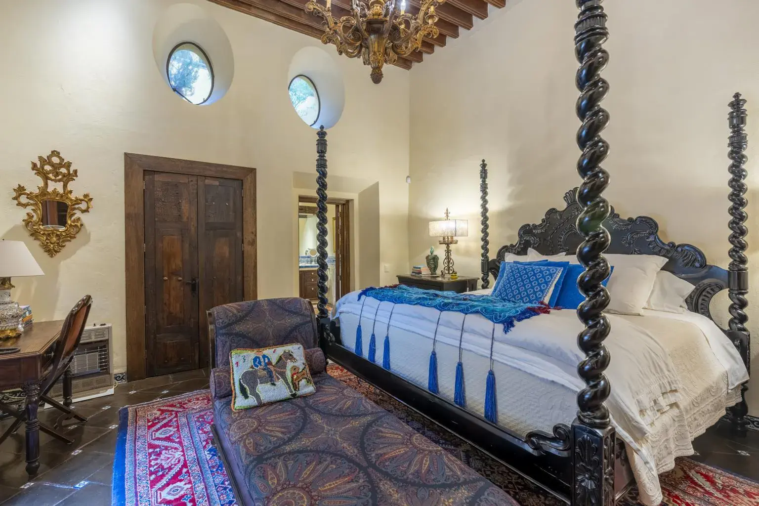 Casa Obelisco, bedroom with a carved four-poster bed and a wood door, San Miguel de Allende