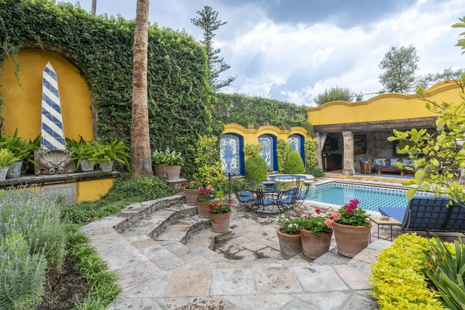 Casa Obelisco, walled garden with a pool, a stone obelisk and potted flowers, San Miguel de Allende