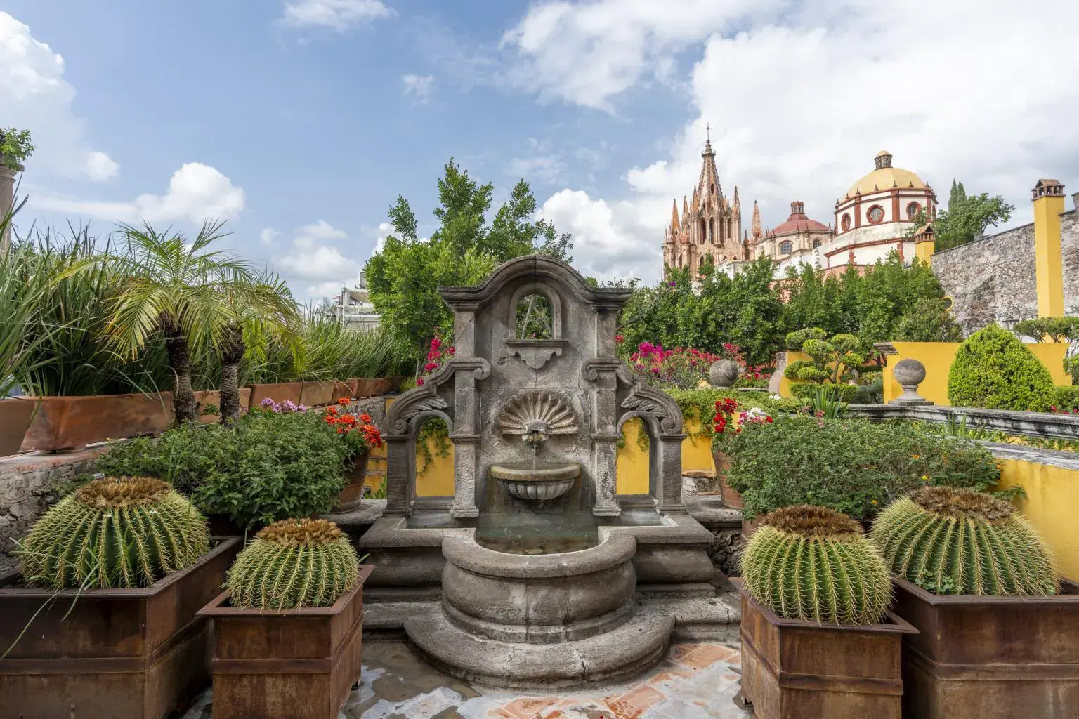 Casa Obelisco, terrace with a stone fountain and barrel cacti overlooking the Parroquia, San Miguel de Allende