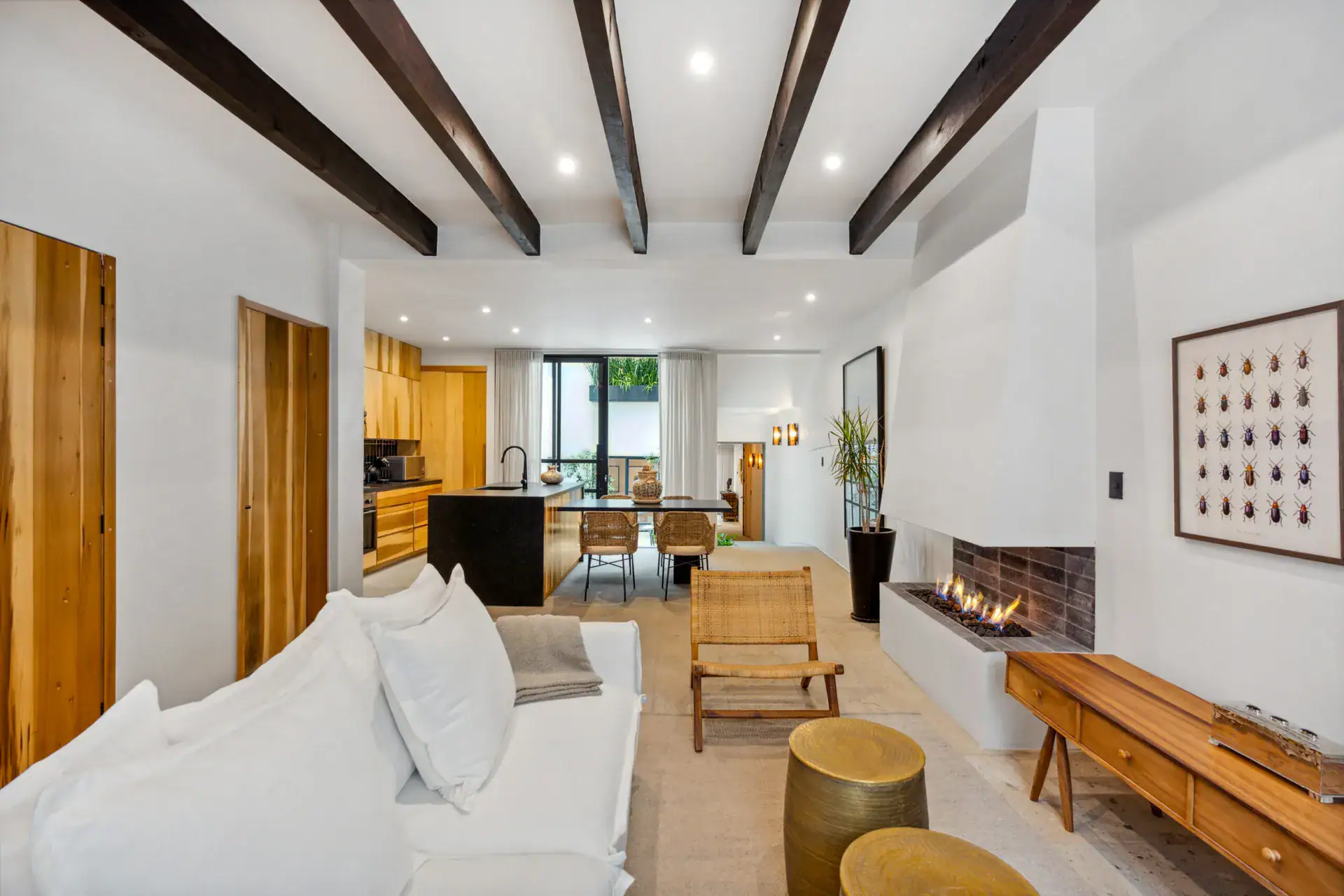 Casa Palma, living room with a white sofa, a linear fireplace and a dark beam ceiling, San Miguel de Allende