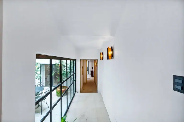 Casa Palma, hallway with a glass wall to the courtyard and a long corridor, San Miguel de Allende