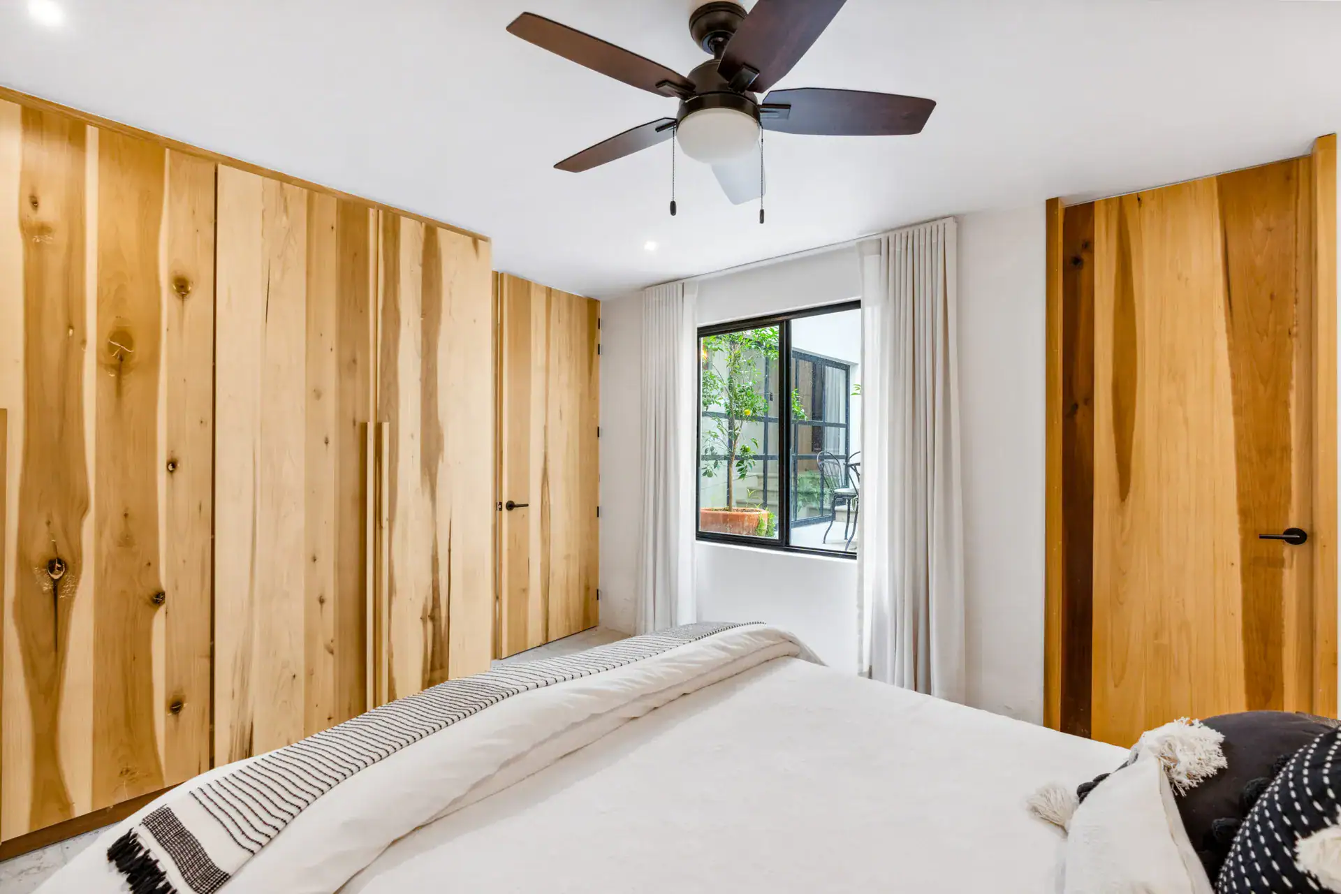 Casa Palma, bedroom with built-in wood wardrobes, a window and a ceiling fan, San Miguel de Allende