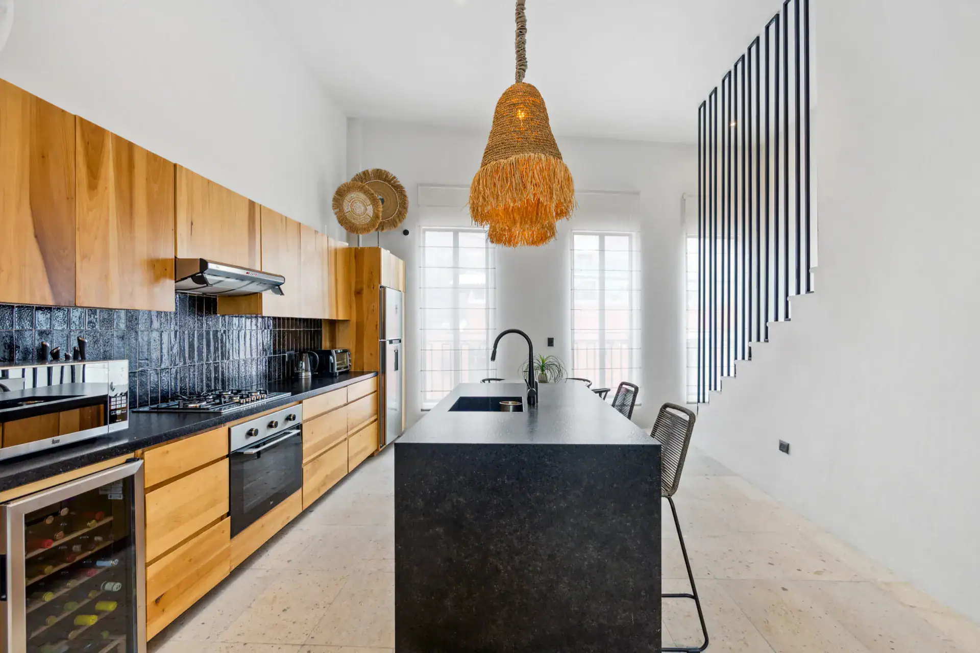 Casa Palma, kitchen with a wine fridge, a black island and tall windows, San Miguel de Allende