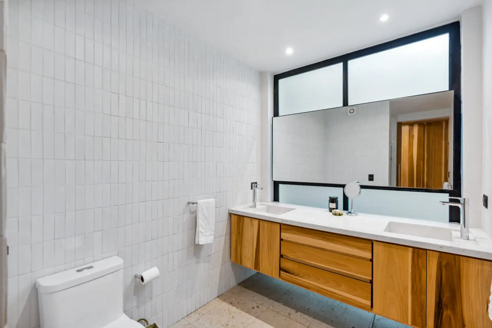 Casa Palma, bathroom with white tile, a wood floating vanity and a large mirror, San Miguel de Allende