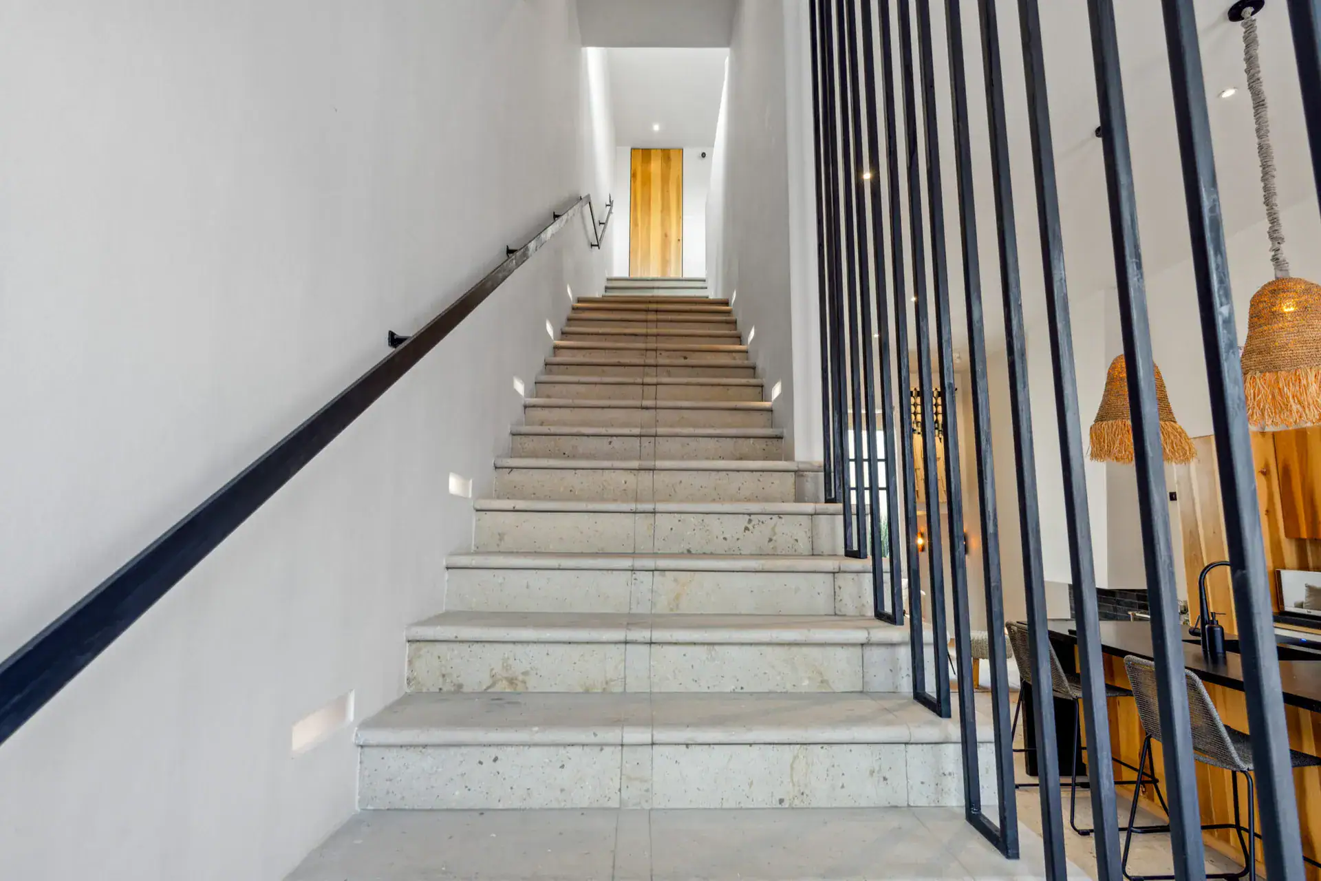 Casa Palma, staircase with stone steps, a black railing and a woven pendant light, San Miguel de Allende