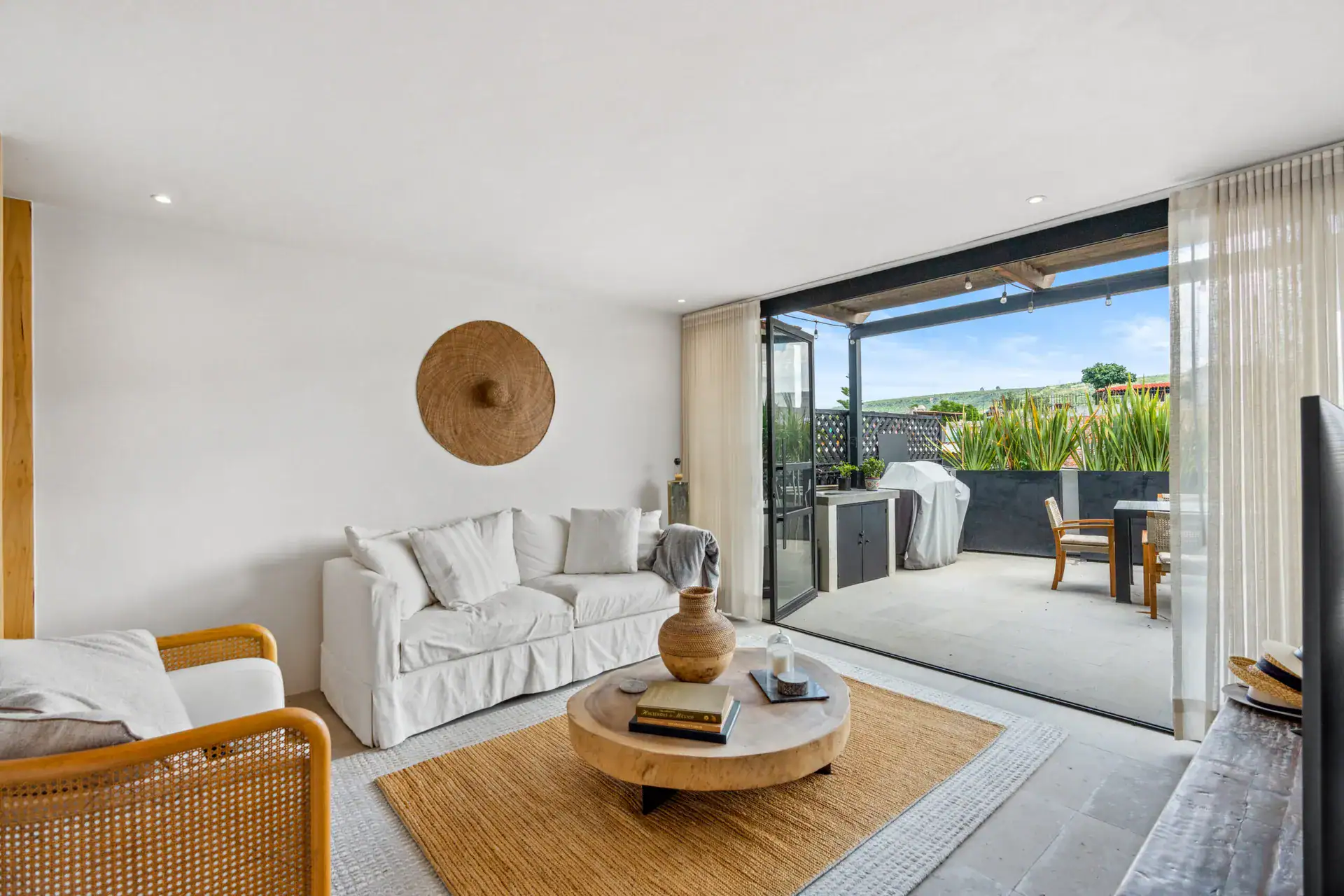 Casa Palma, living room with a white sofa, a round coffee table and a view to the rooftop terrace, San Miguel de Allende