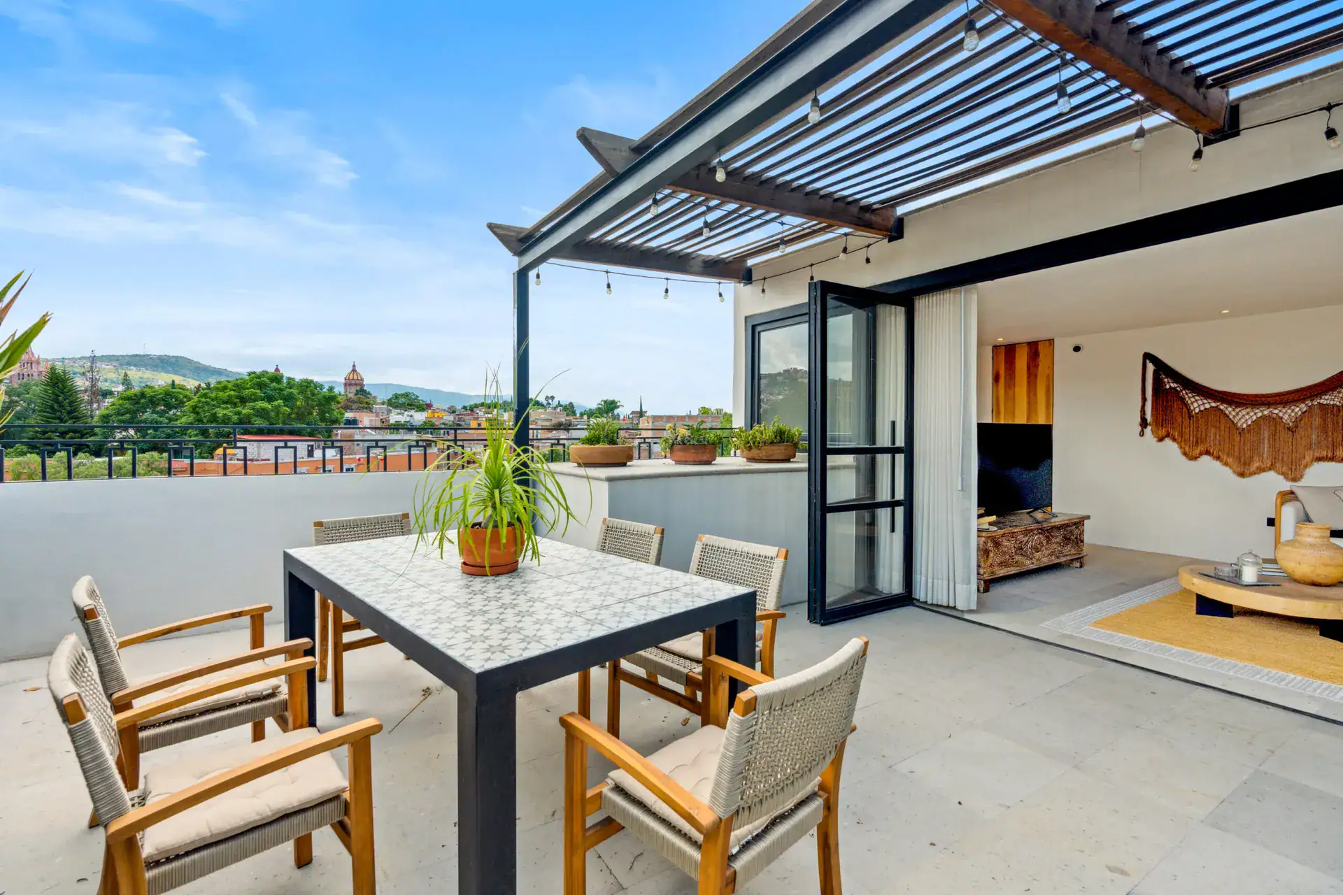 Casa Palma, terrace with a pergola and dining table looking over the rooftops and hills, San Miguel de Allende