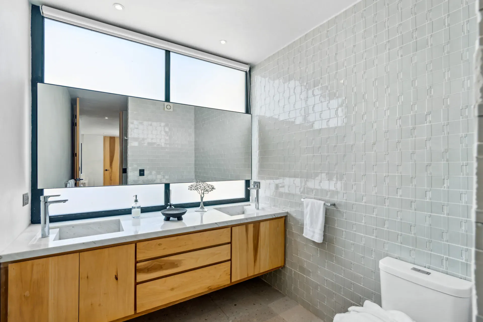 Casa Palma, bathroom with a textured white tile wall, a wood vanity and a large window, San Miguel de Allende