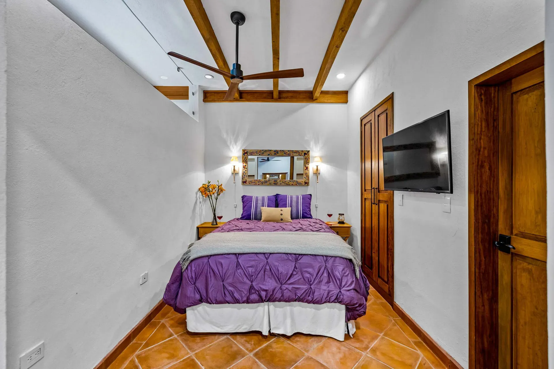 Casa Paradise, bedroom with a purple bedspread and a beamed ceiling, San Miguel de Allende