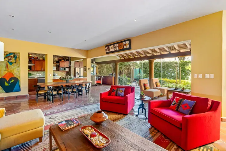 Casa Privada, open living, dining and kitchen area with terracotta floors and glass doors to a courtyard, San Miguel de Allende
