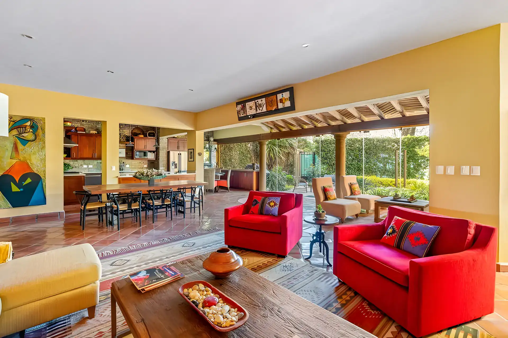 Casa Privada, open living, dining and kitchen area with terracotta floors and glass doors to a courtyard, San Miguel de Allende
