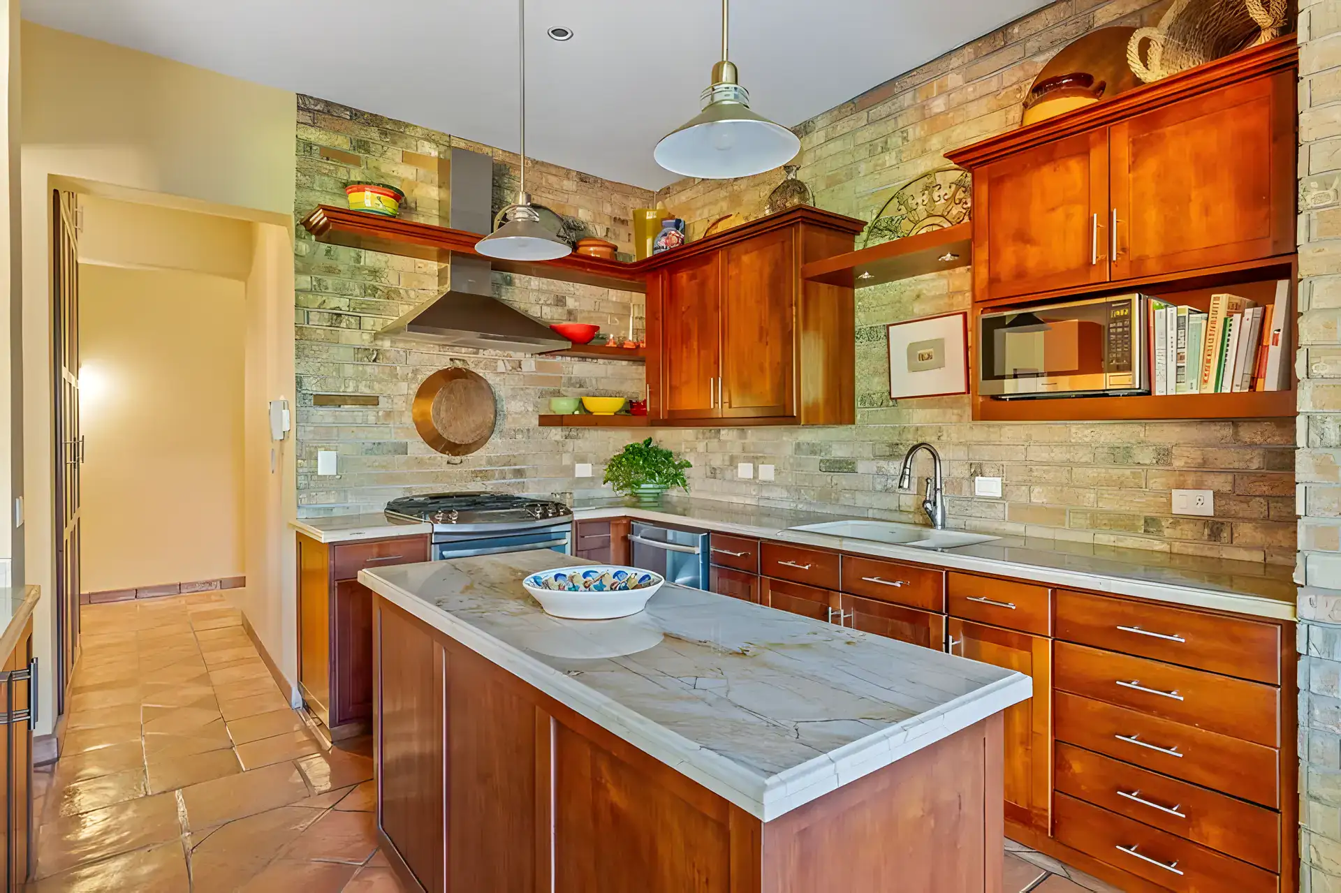 Casa Privada, kitchen with wood cabinets, a brick backsplash, a range hood and a stone-topped island, San Miguel de Allende