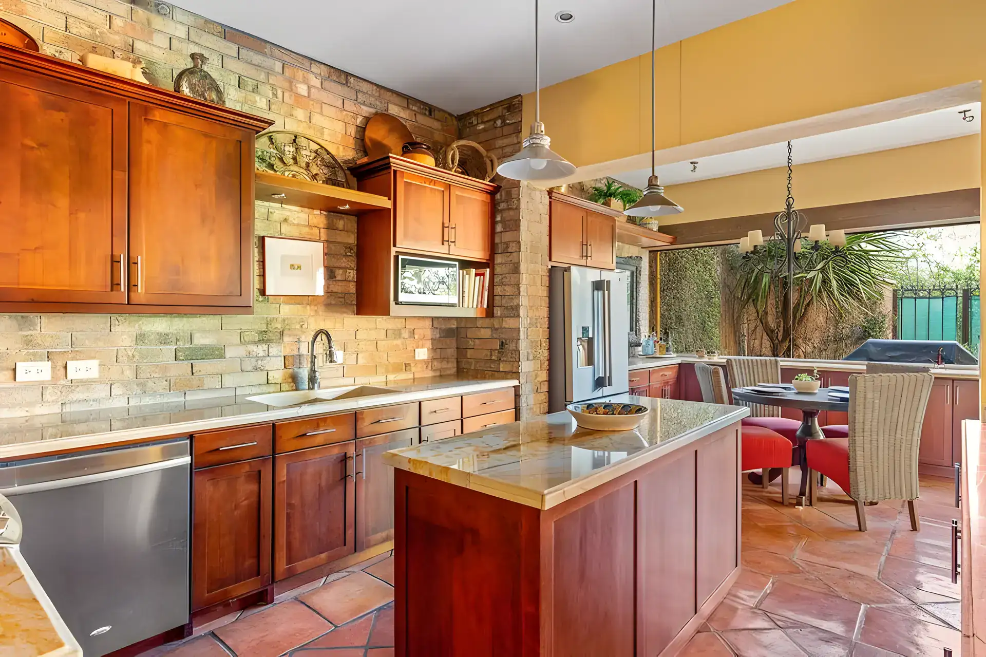 Casa Privada, kitchen island, stainless dishwasher and a breakfast table with red chairs, San Miguel de Allende