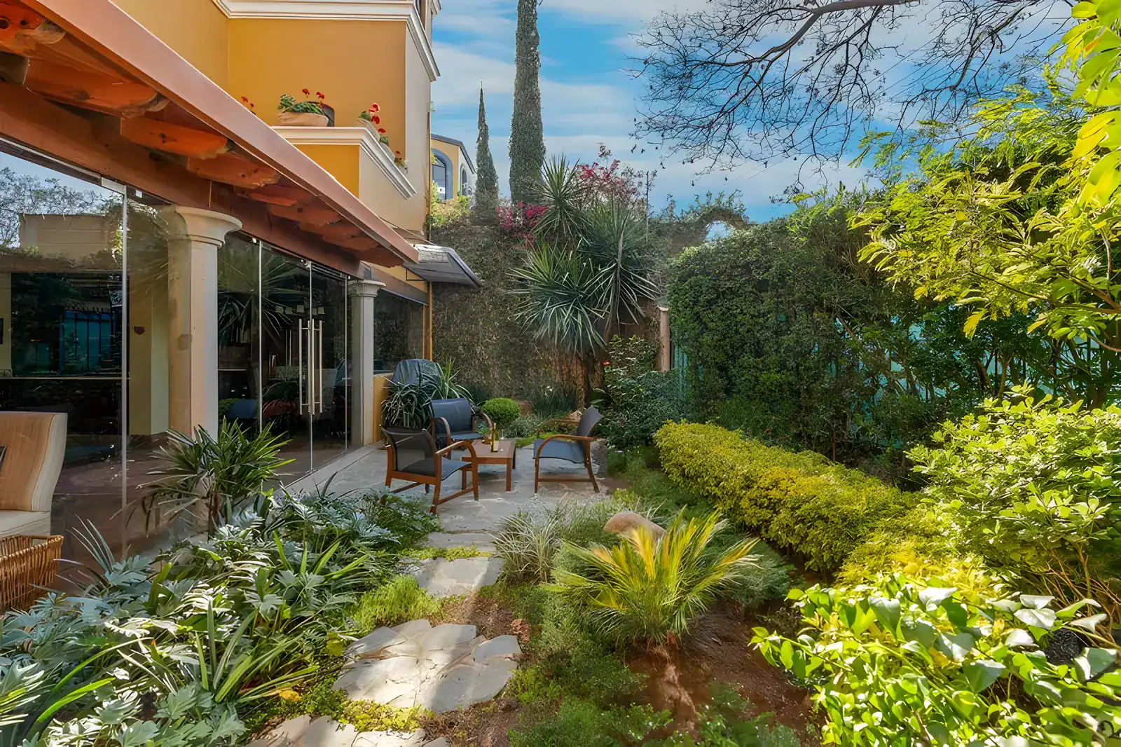 Casa Privada, garden with a hedge, flagstone path and a loggia with columns, San Miguel de Allende