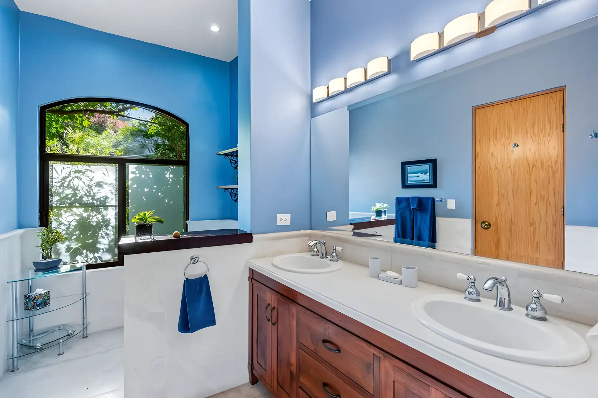 Casa Privada, bathroom with a double sink vanity, a marble counter and an arched window, San Miguel de Allende
