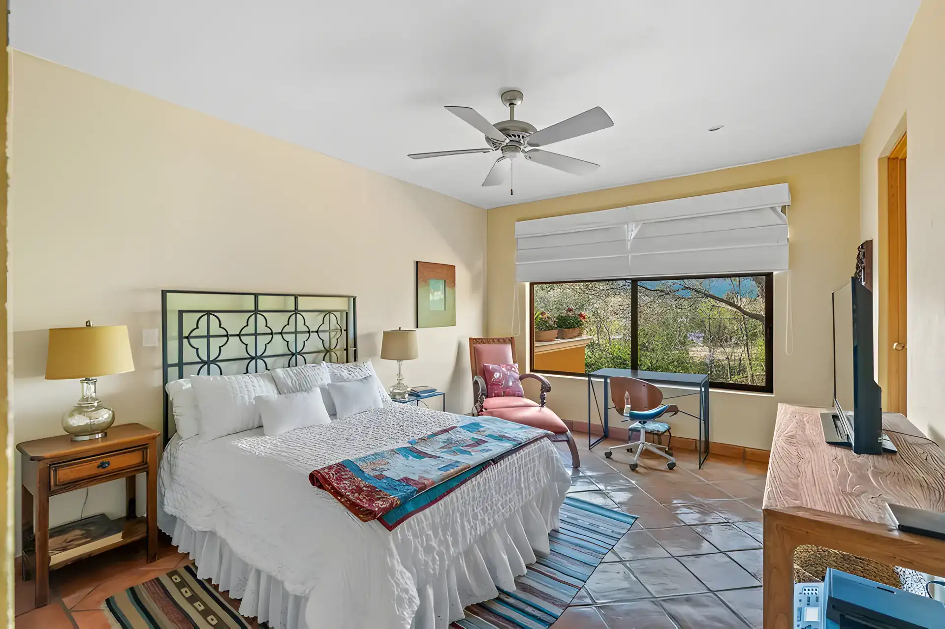 Casa Privada, bedroom with a geometric iron headboard, a ruffled white bedspread and a window to the garden, San Miguel de Allende