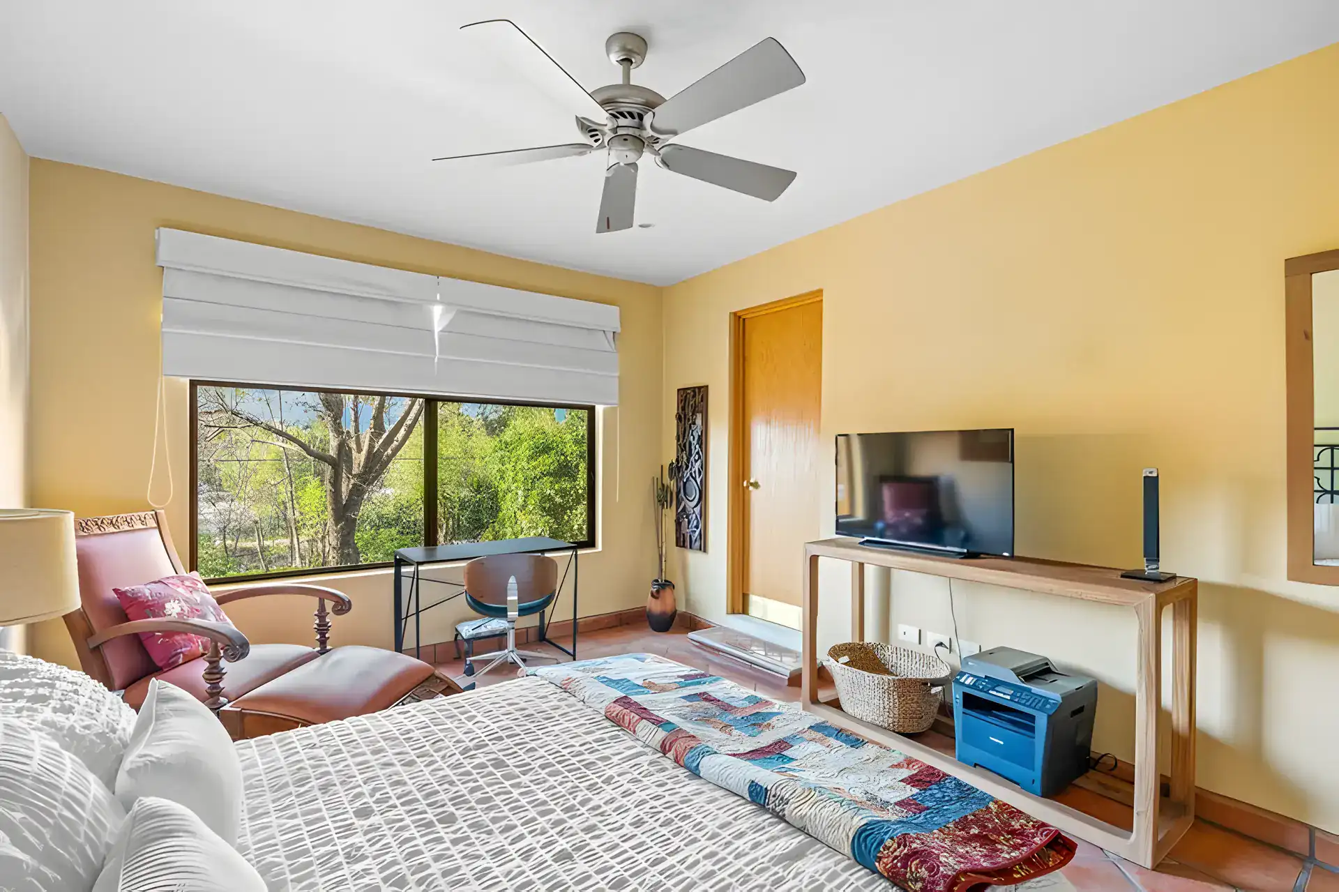 Casa Privada, bedroom with a ceiling fan, a television console and a large window with a Roman shade, San Miguel de Allende