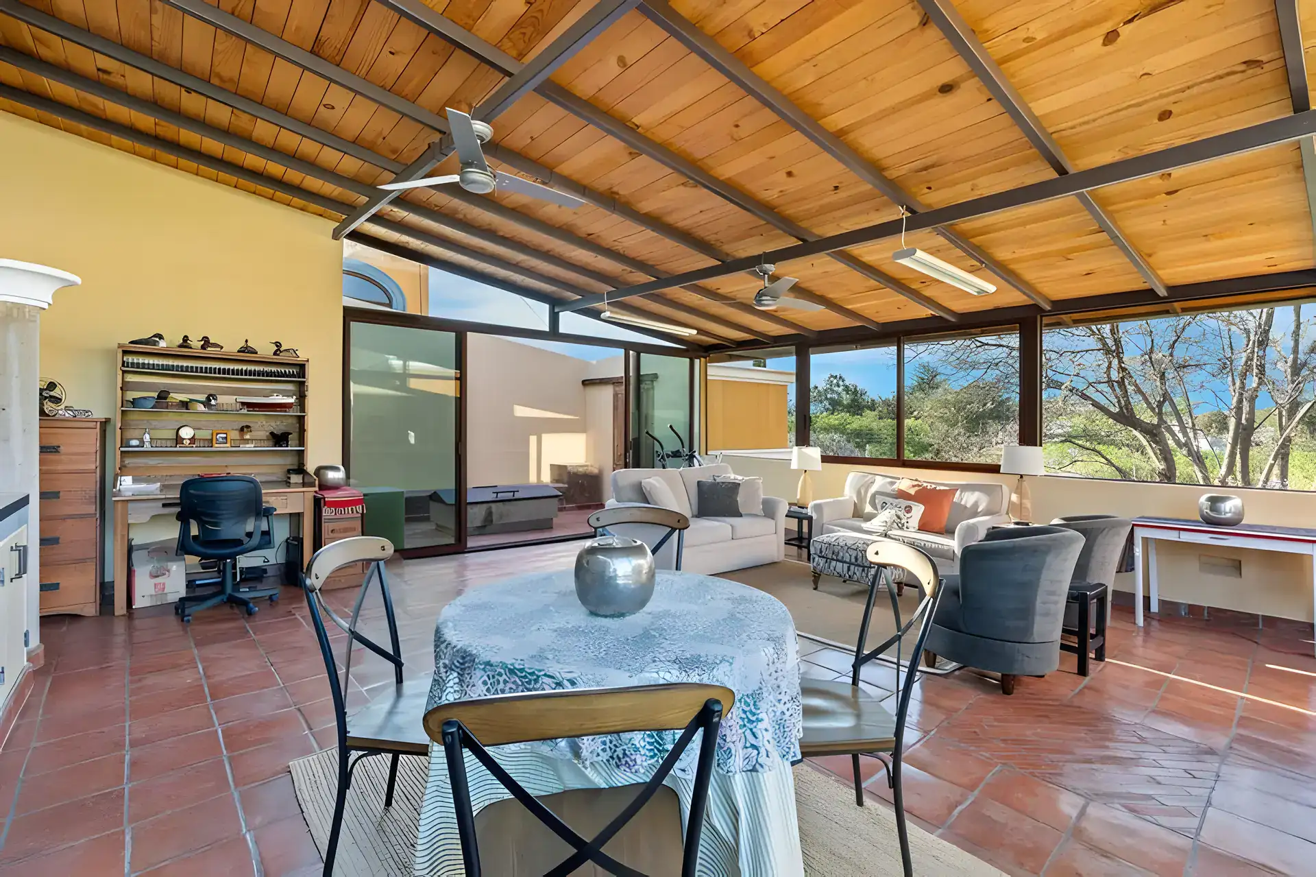 Casa Privada, covered rooftop room with a dining table, desk, sofas and floor-to-ceiling glass facing the hills, San Miguel de Allende