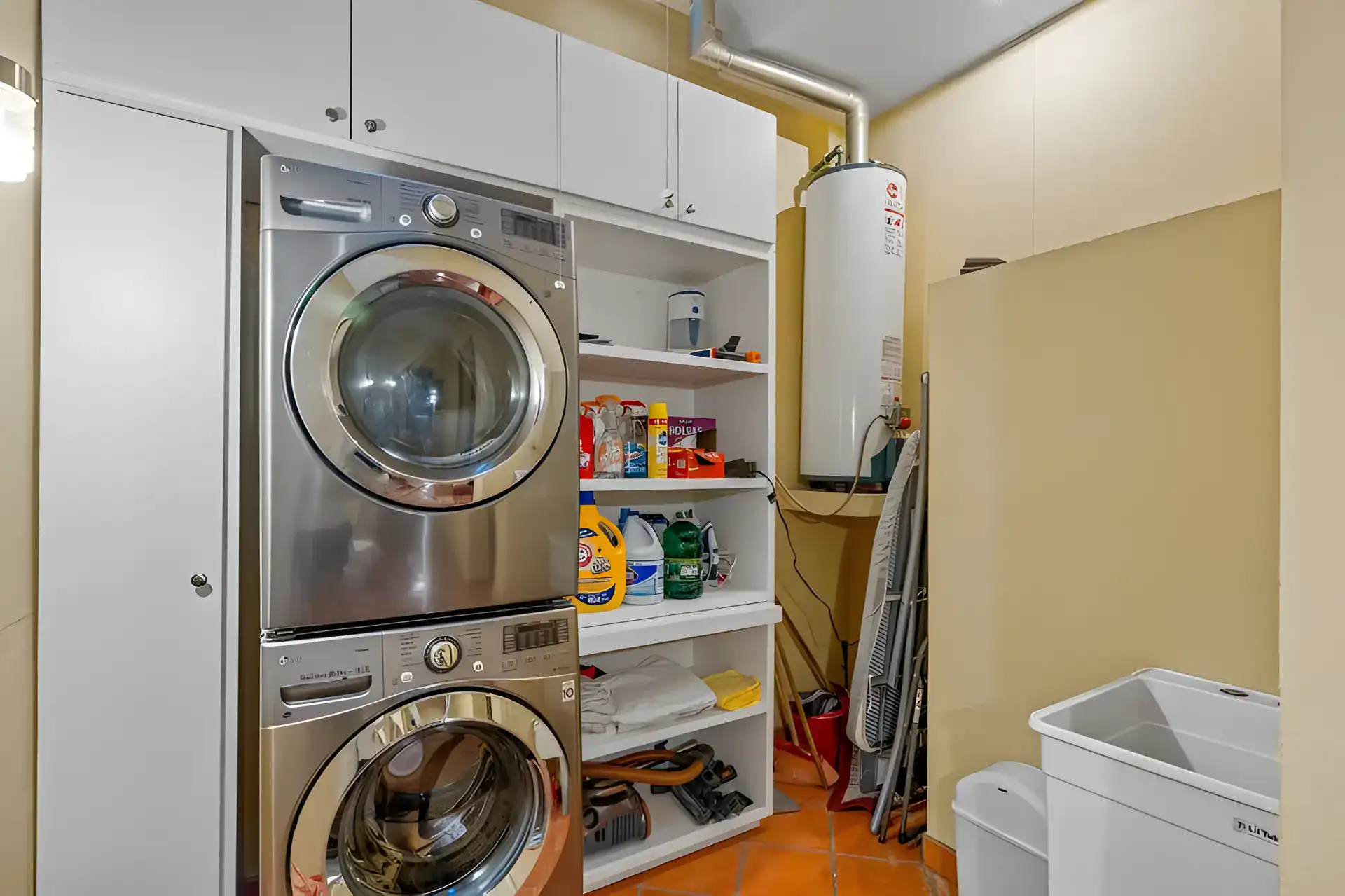 Casa Privada, laundry room with a stacked washer and dryer, a water heater and storage shelves, San Miguel de Allende