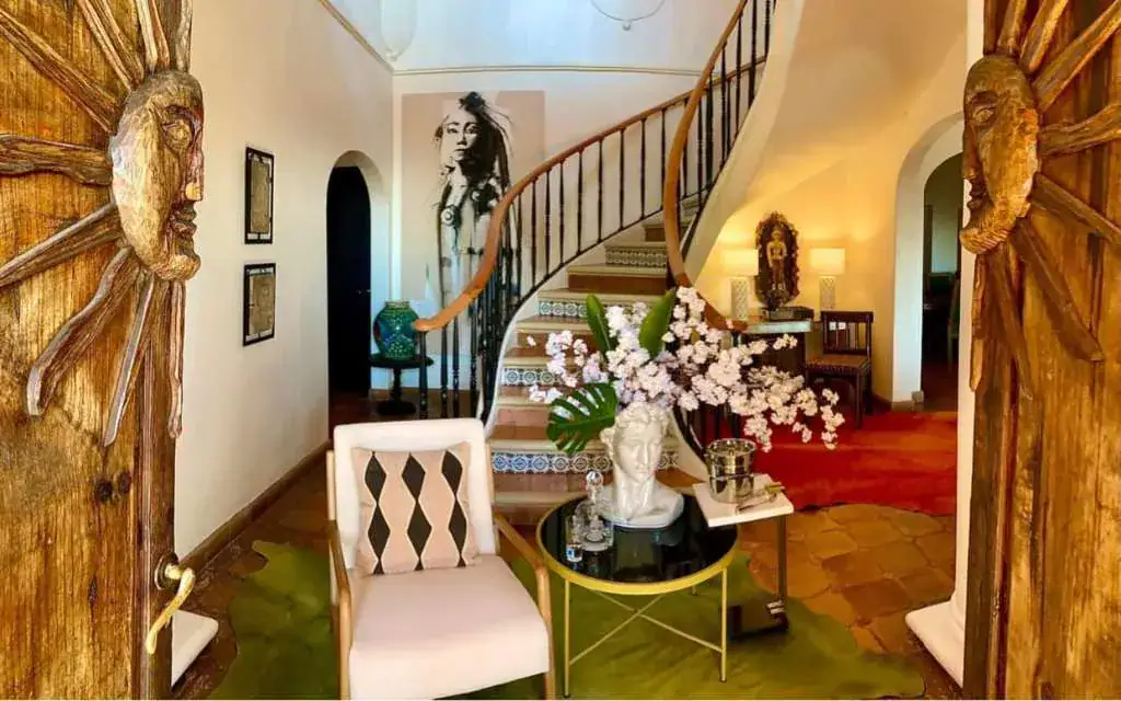 Casa Puesta del Sol, entry hall with carved sun doors and a spiral stair, San Miguel de Allende